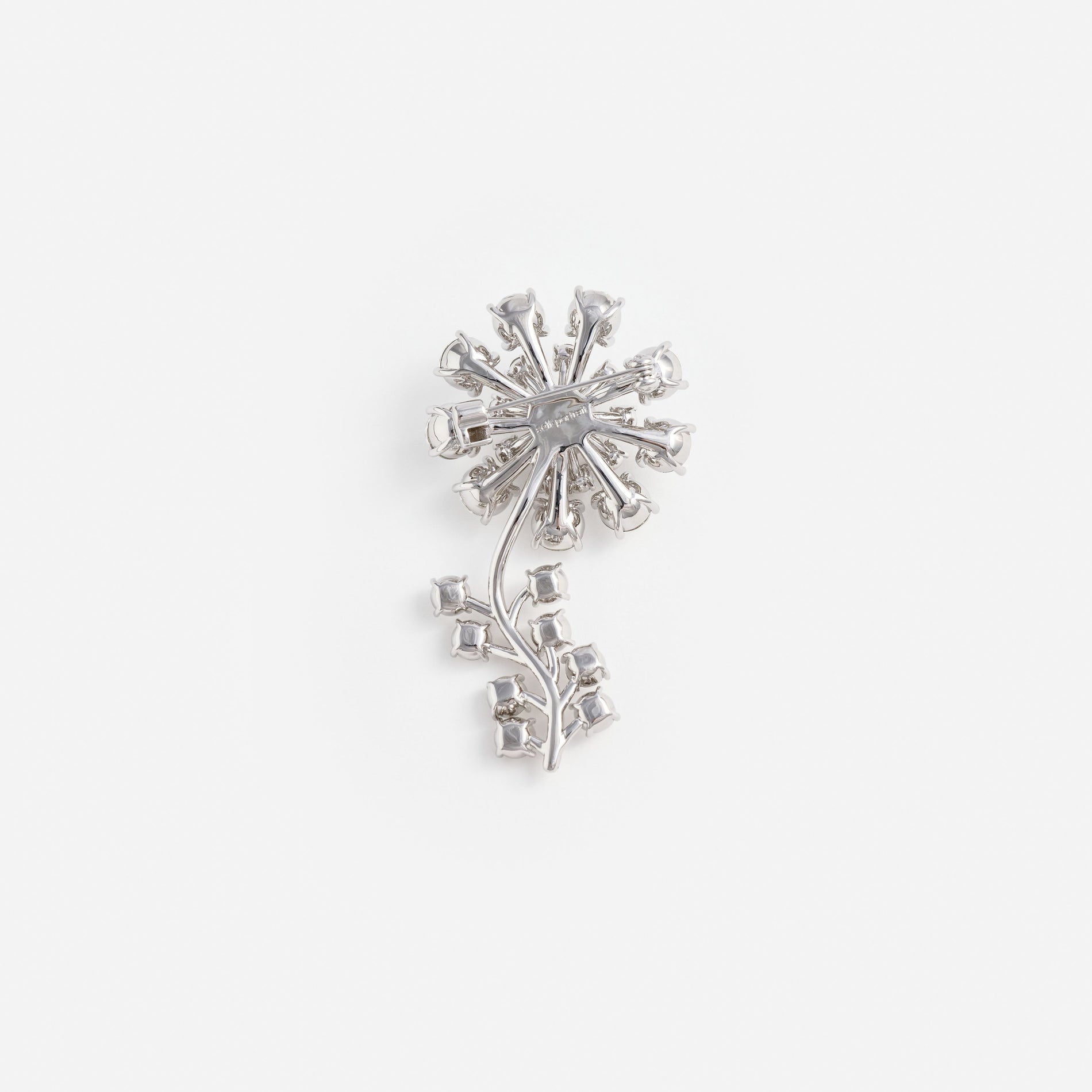 Back of a silver brooch with a flower and stem design, showing the pin and clasp mechanism