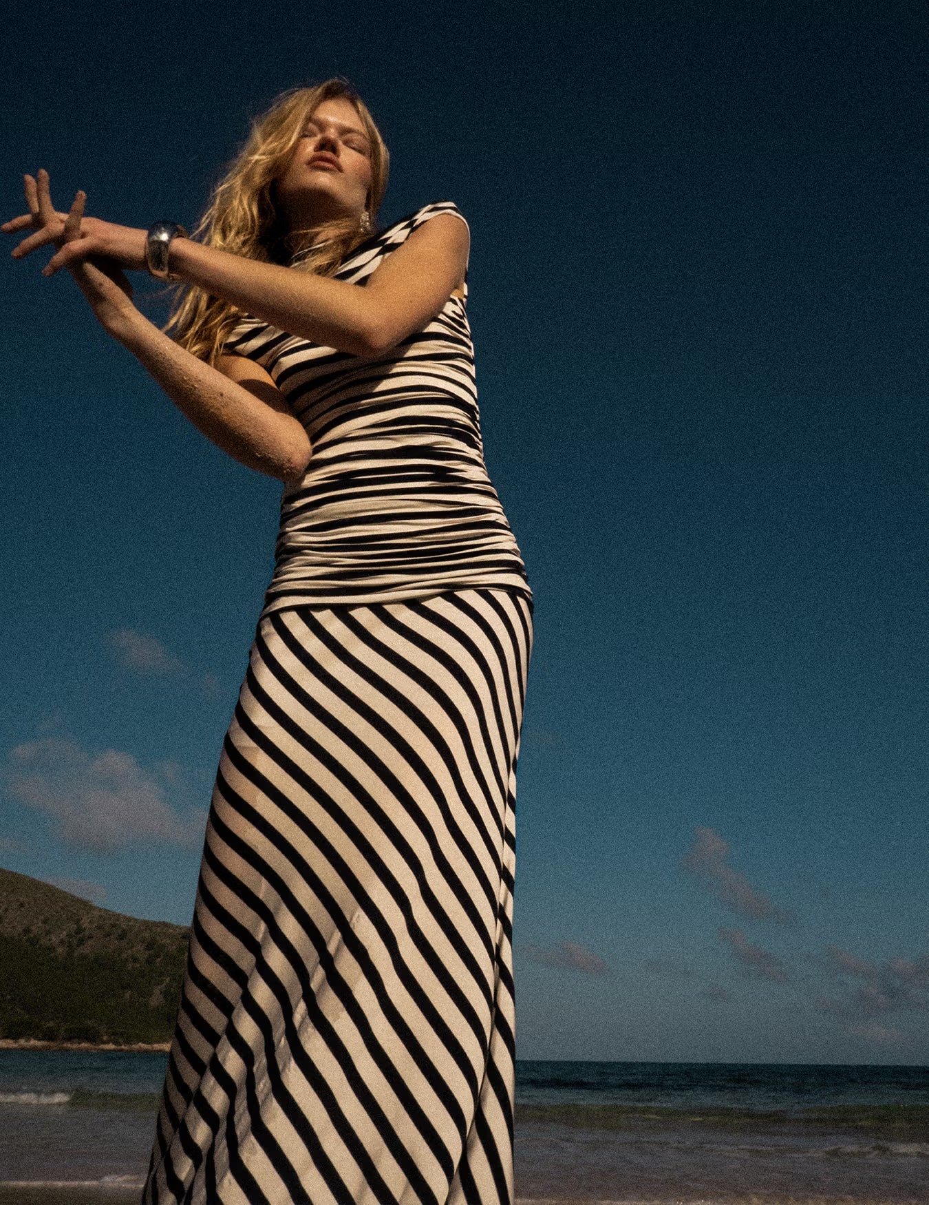 A lifestyle image of a woman wearing the Navy Stripe Jersey Maxi Dress