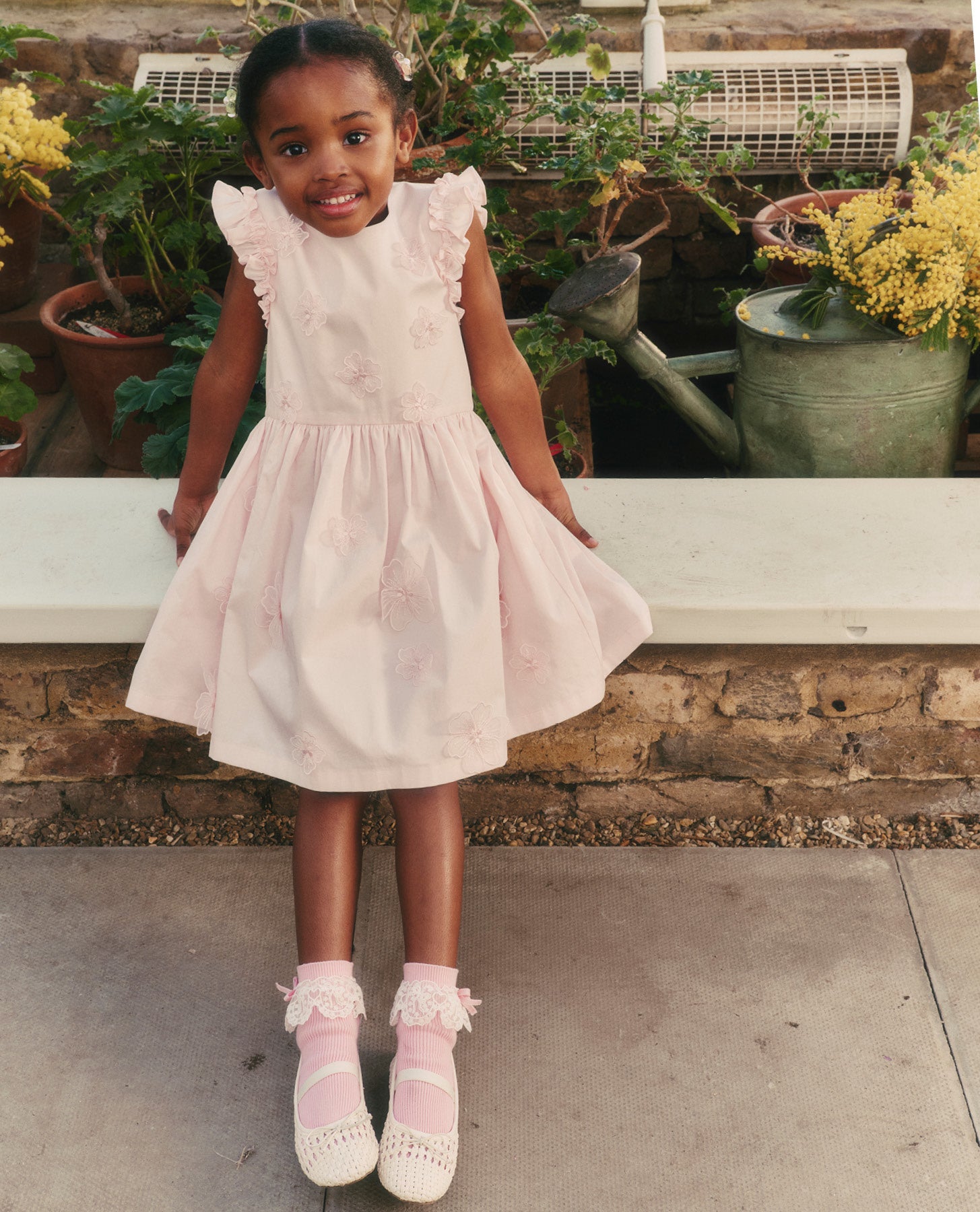 A close up of a woman wearing the Pink Cotton Flower Dress