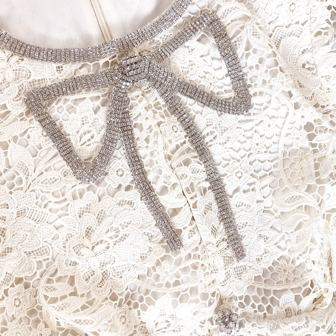 A close up of the fabric for the Cream Cord Lace Bow Mini Dress