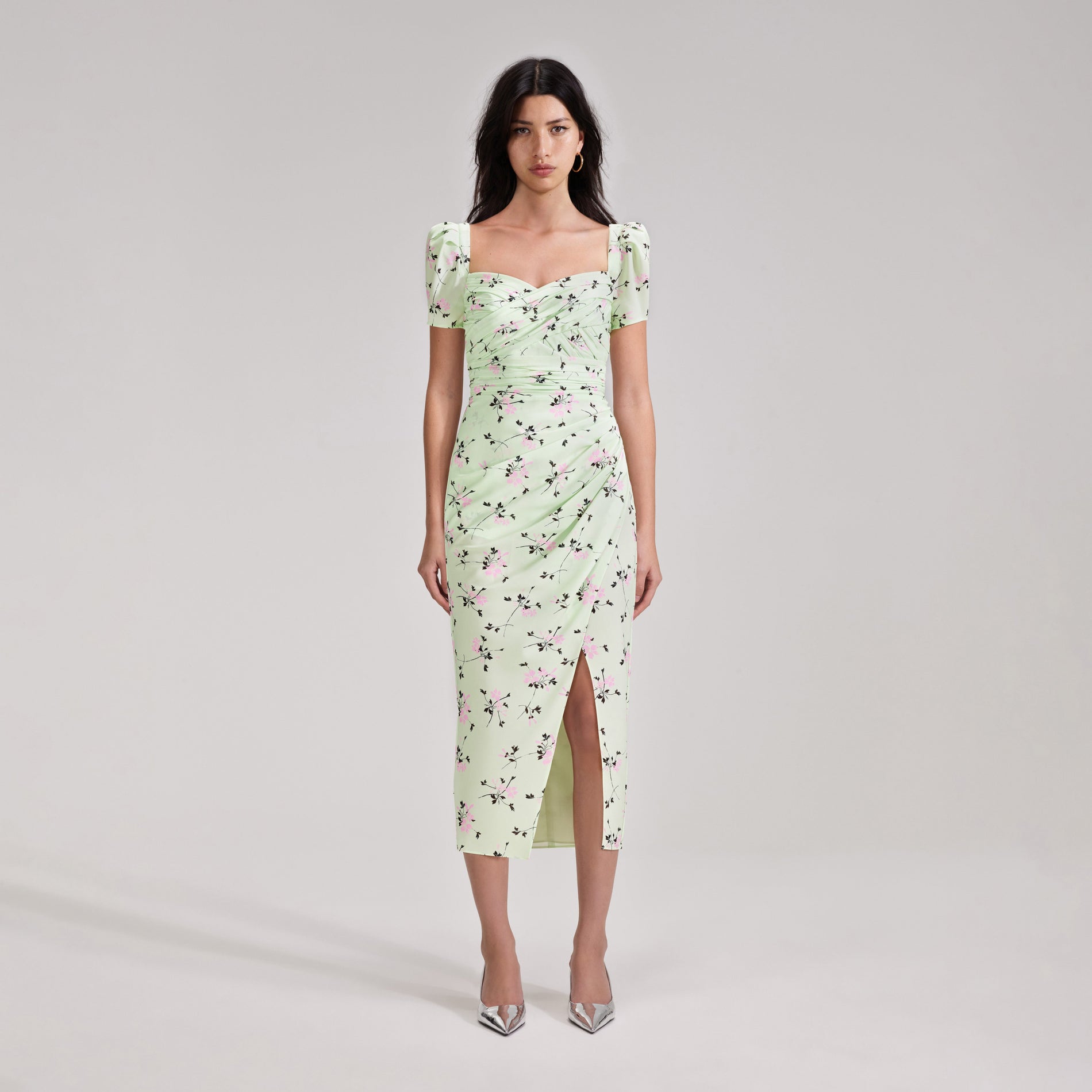 A woman wearing the Green Floral Print Iris Midi Dress