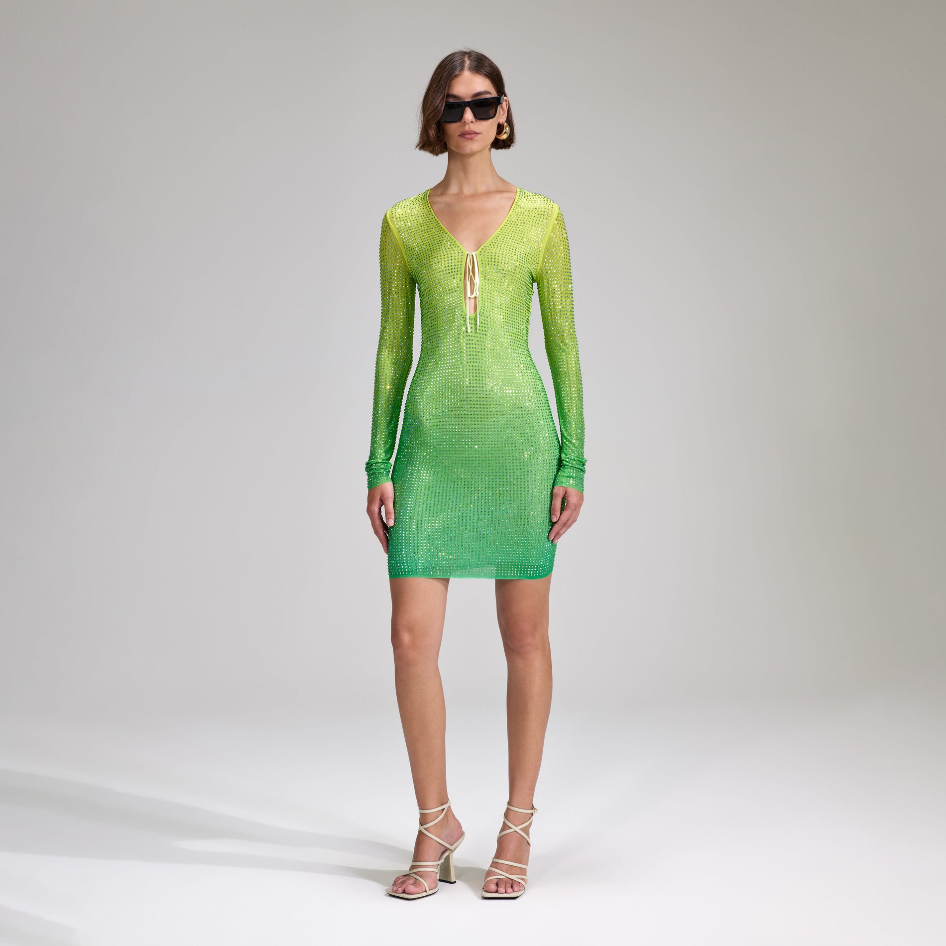 A woman wearing the Green Rhinestone Mesh Keyhole Mini Dress