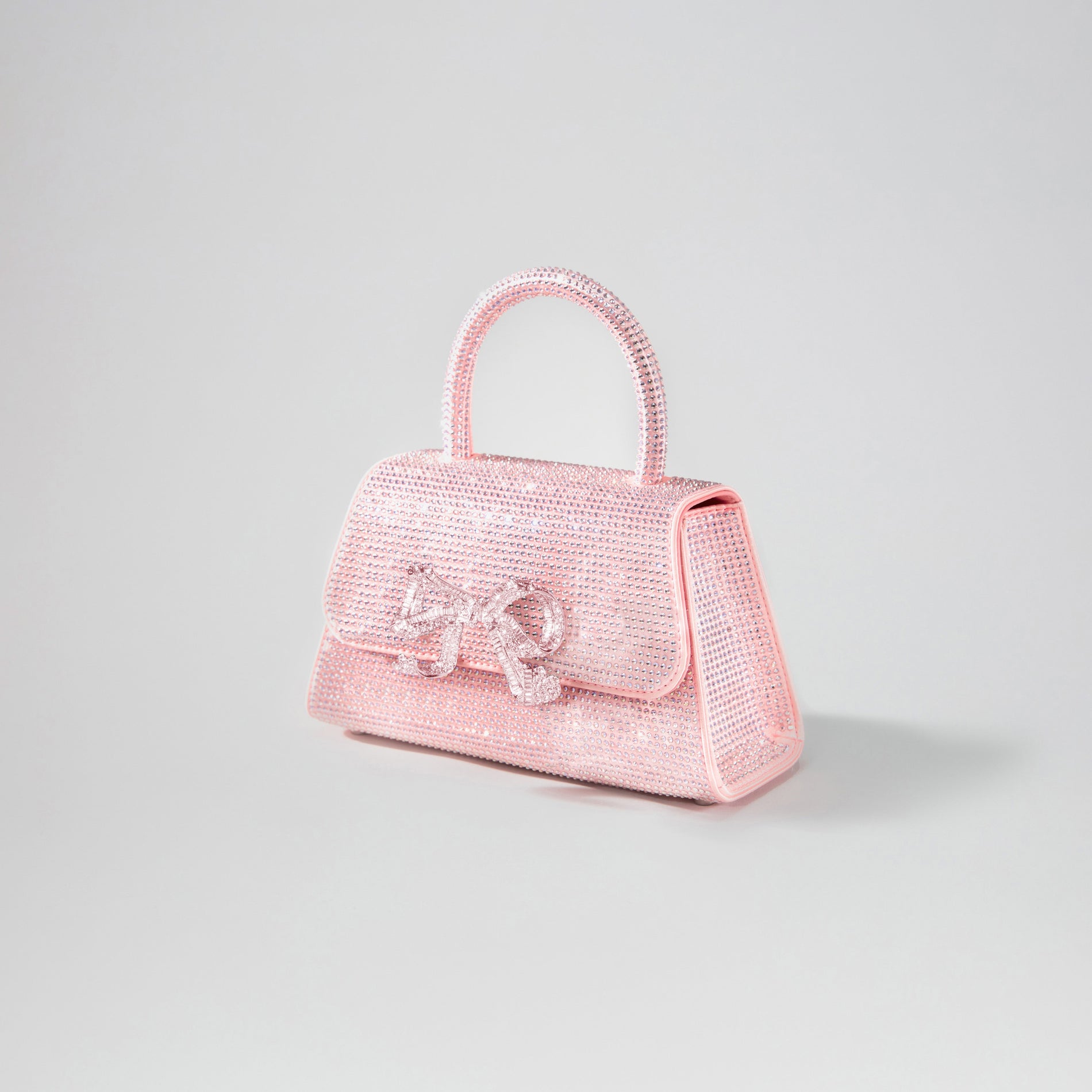 Side view of a woman wearing the Pink Rhinestone Mini Bow Bag