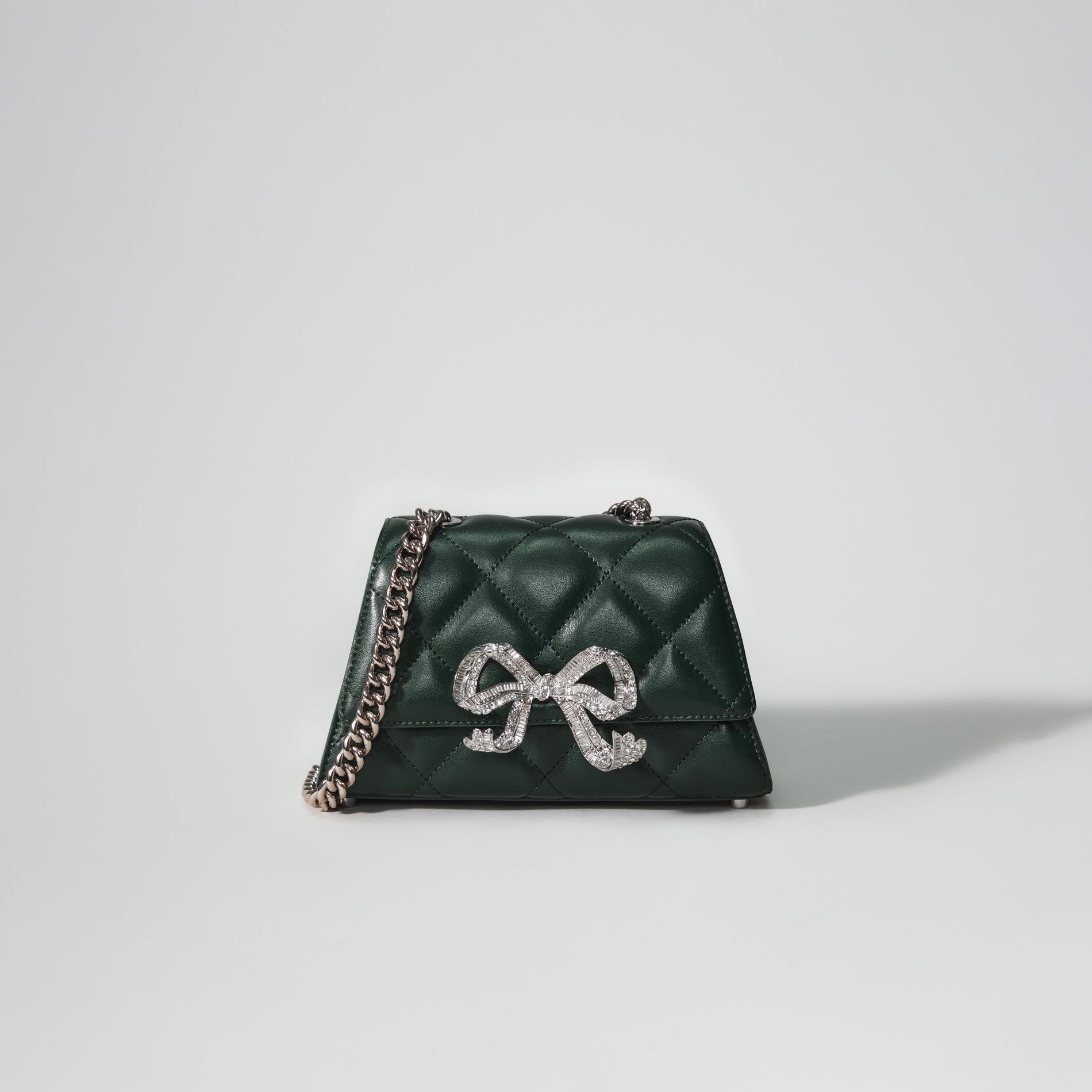 A woman wearing the Green Quilted Shoulder Mini Bow Bag