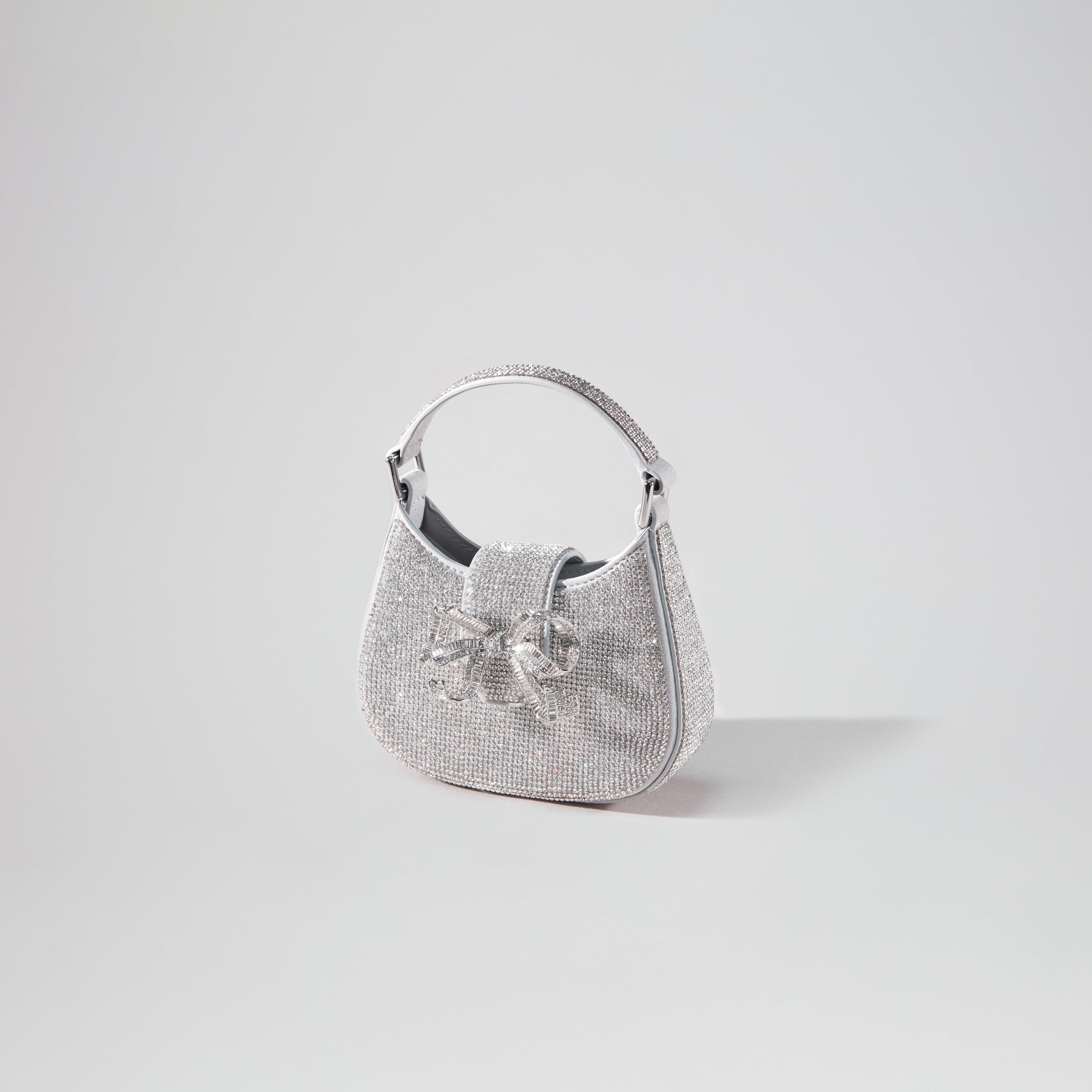 Side view of a woman wearing the Silver Rhinestone Crescent Bow Micro Bag