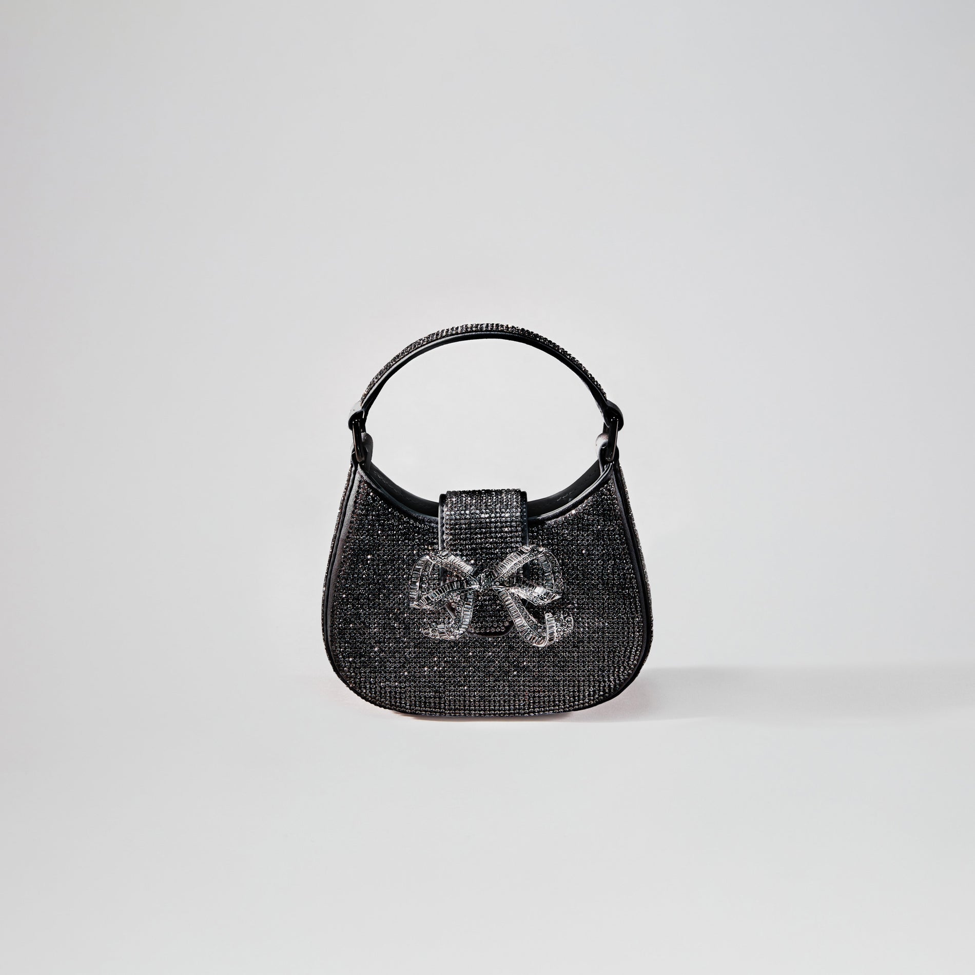 A woman wearing the Black Rhinestone Crescent Bow Micro Bag
