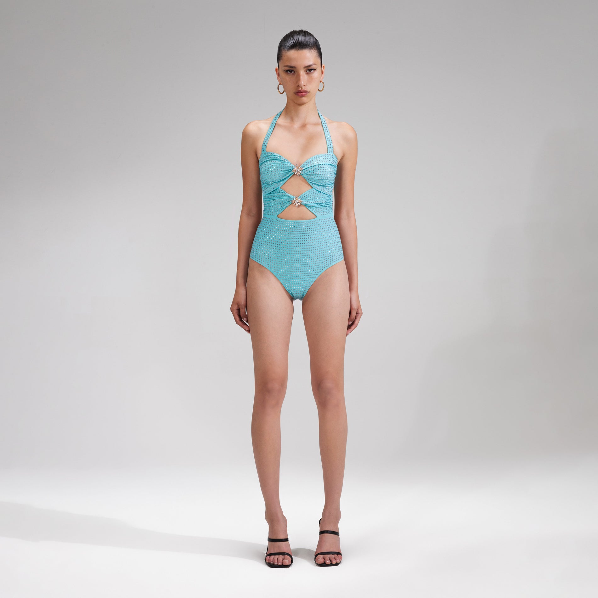 A woman wearing the Pale Blue Rhinestone Swimsuit