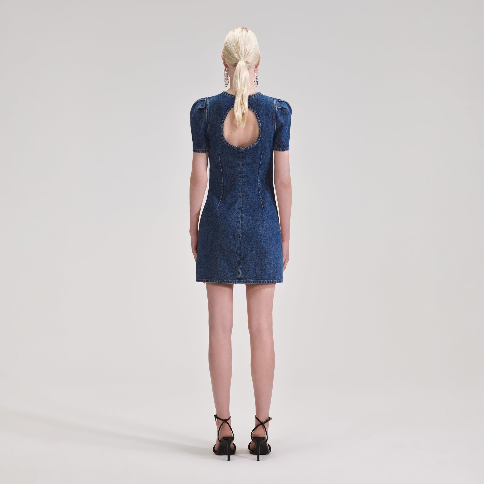 A woman wearing the Lace Bib Denim Mini Dress