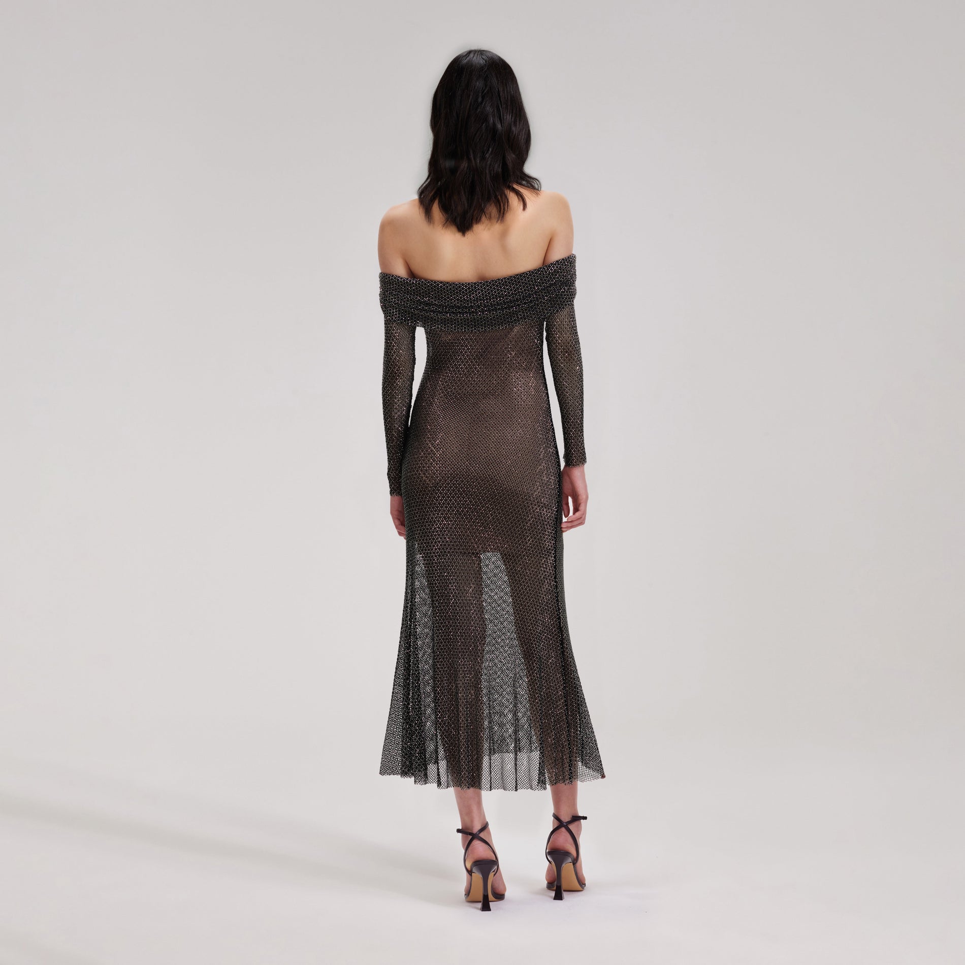 A woman wearing the Black Rhinestone Fishnet Midi Dress