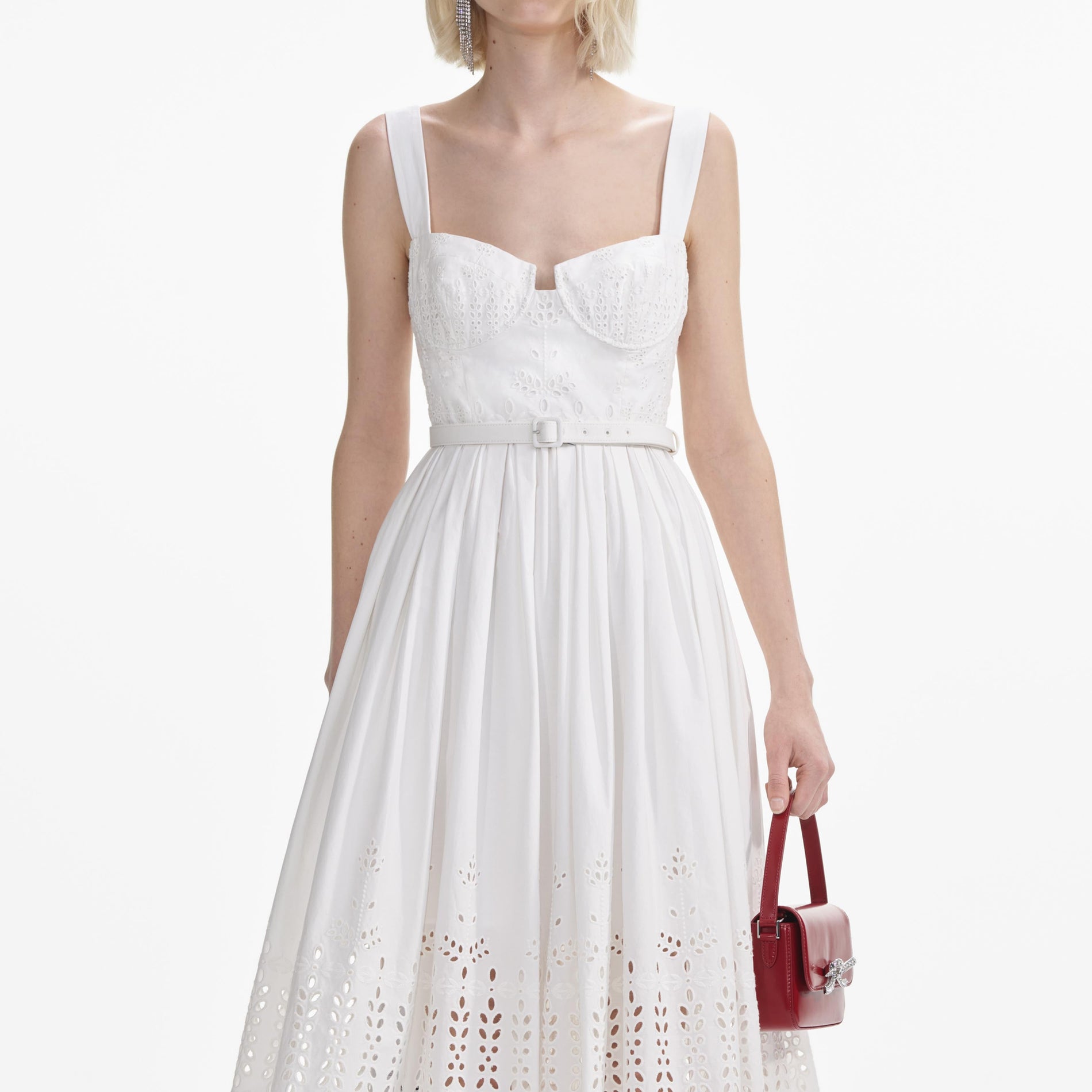 A close up of a woman wearing the White Cotton Broderie Midi Dress