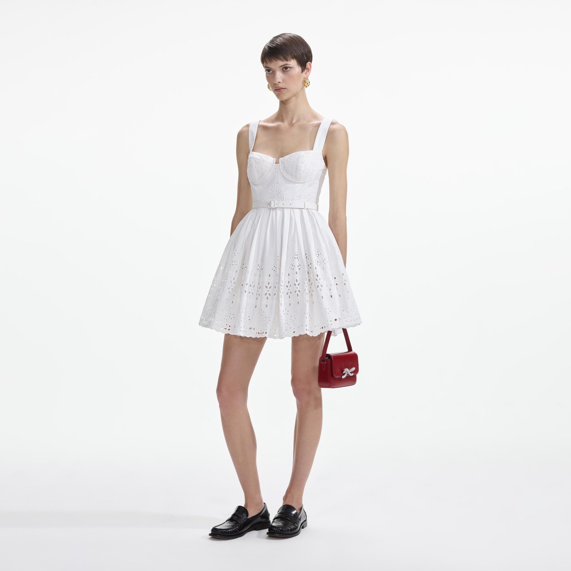 Side view of a woman wearing the White Cotton Broderie Mini Dress