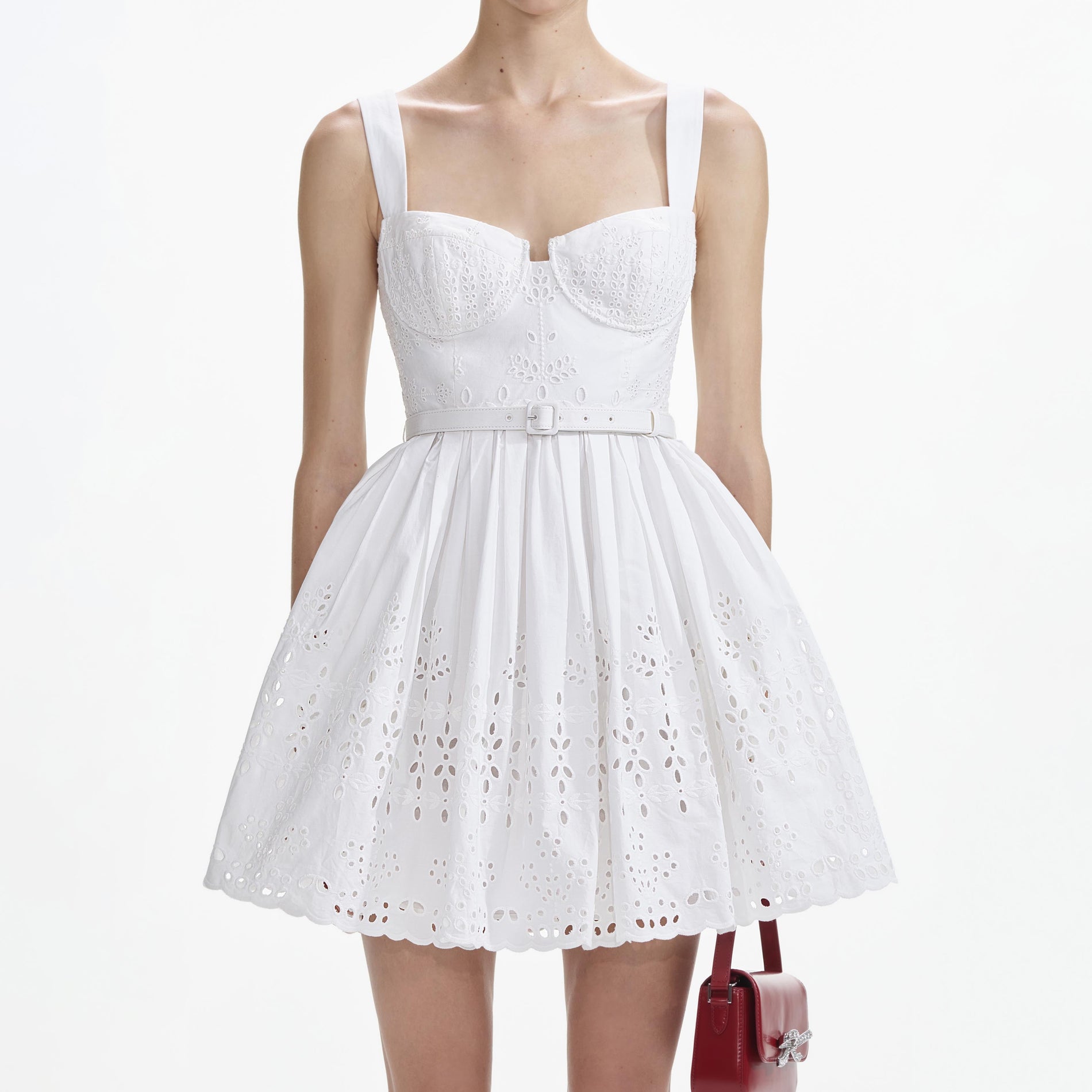 A close up of a woman wearing the White Cotton Broderie Mini Dress