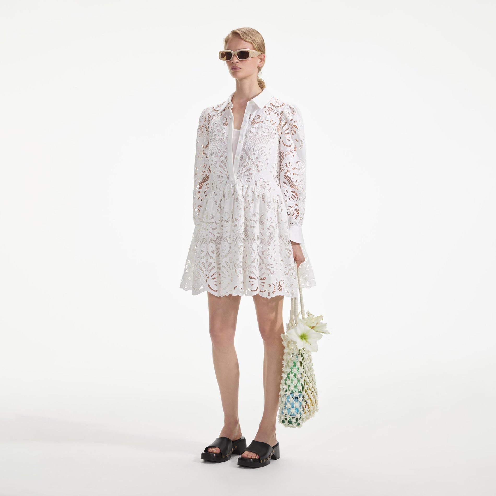 Side view of a woman wearing the White Cotton Lace Mini Shirt Dress