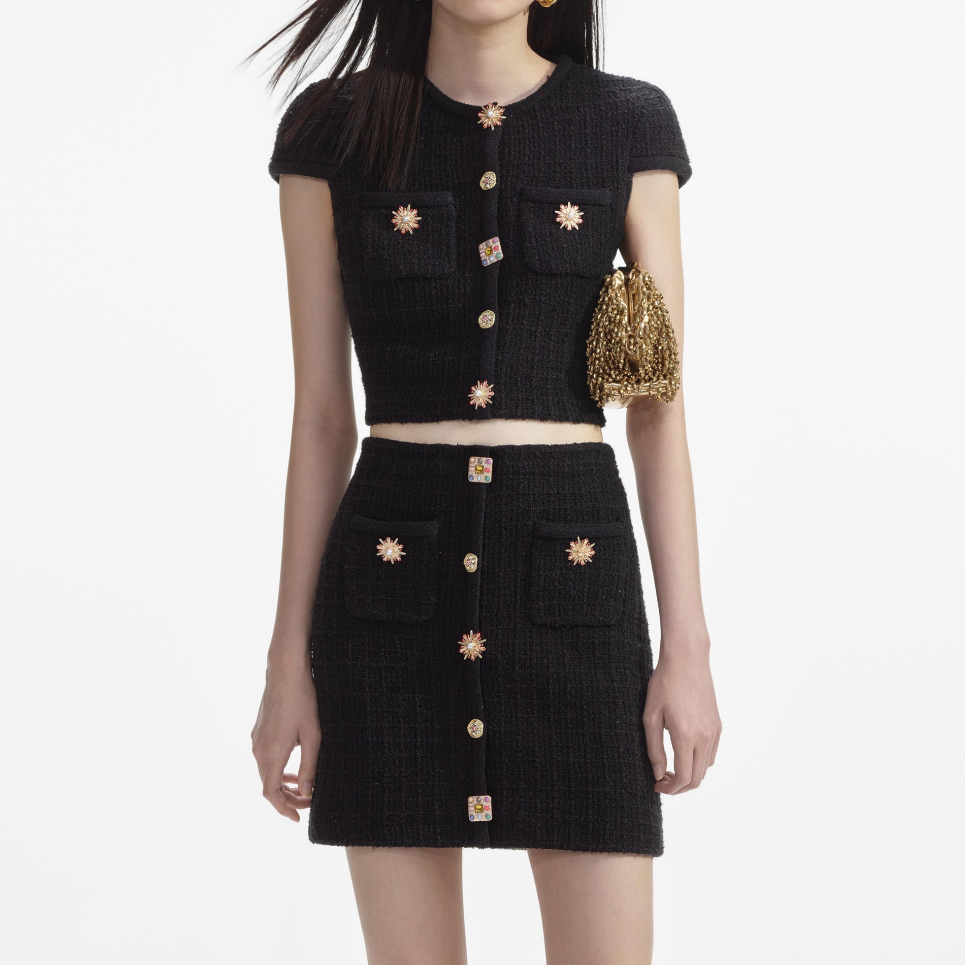 A close up of a woman wearing the Black Jewel Button Knit Mini Skirt