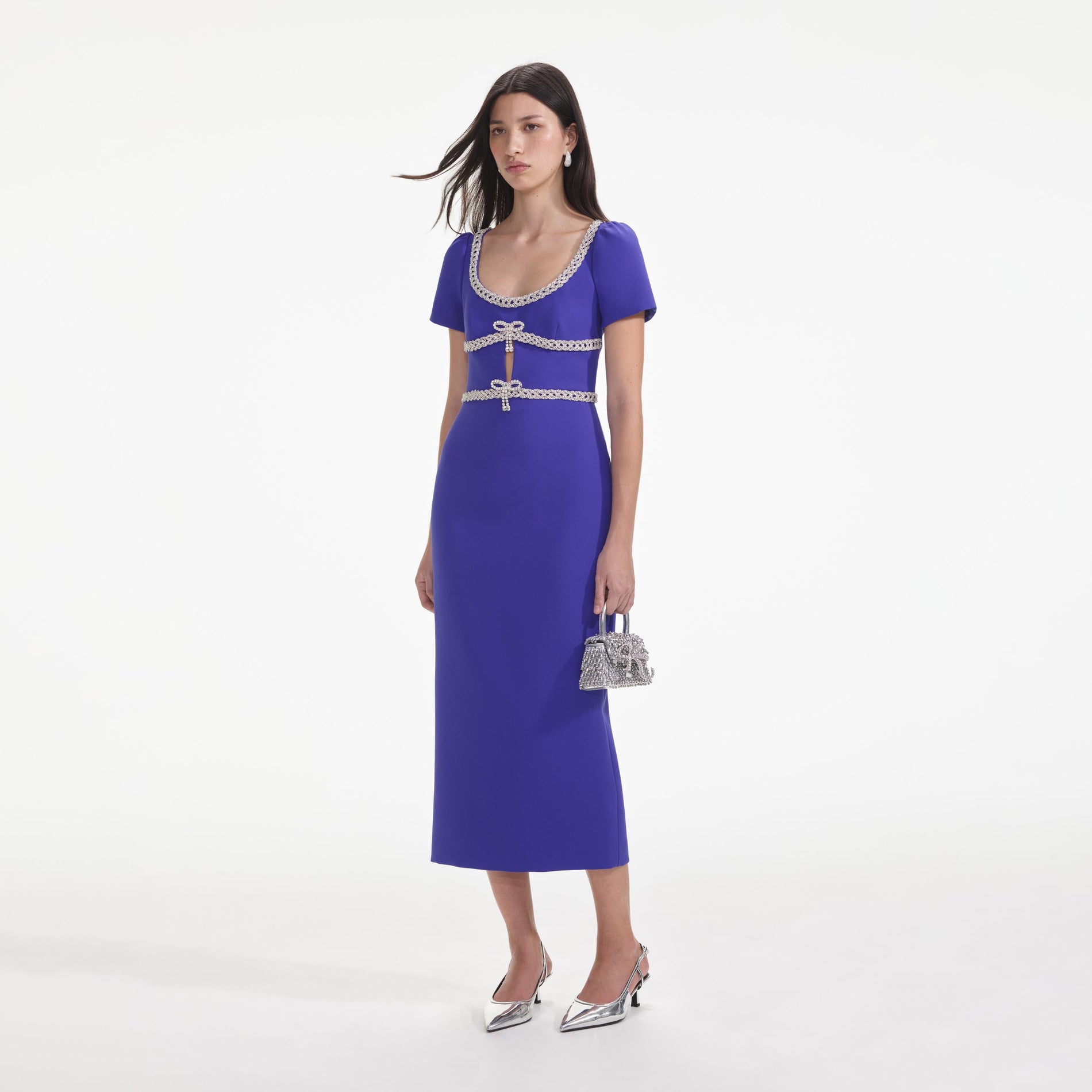 Side view of a woman wearing the Blue Diamante Bow Trim Midi Dress
