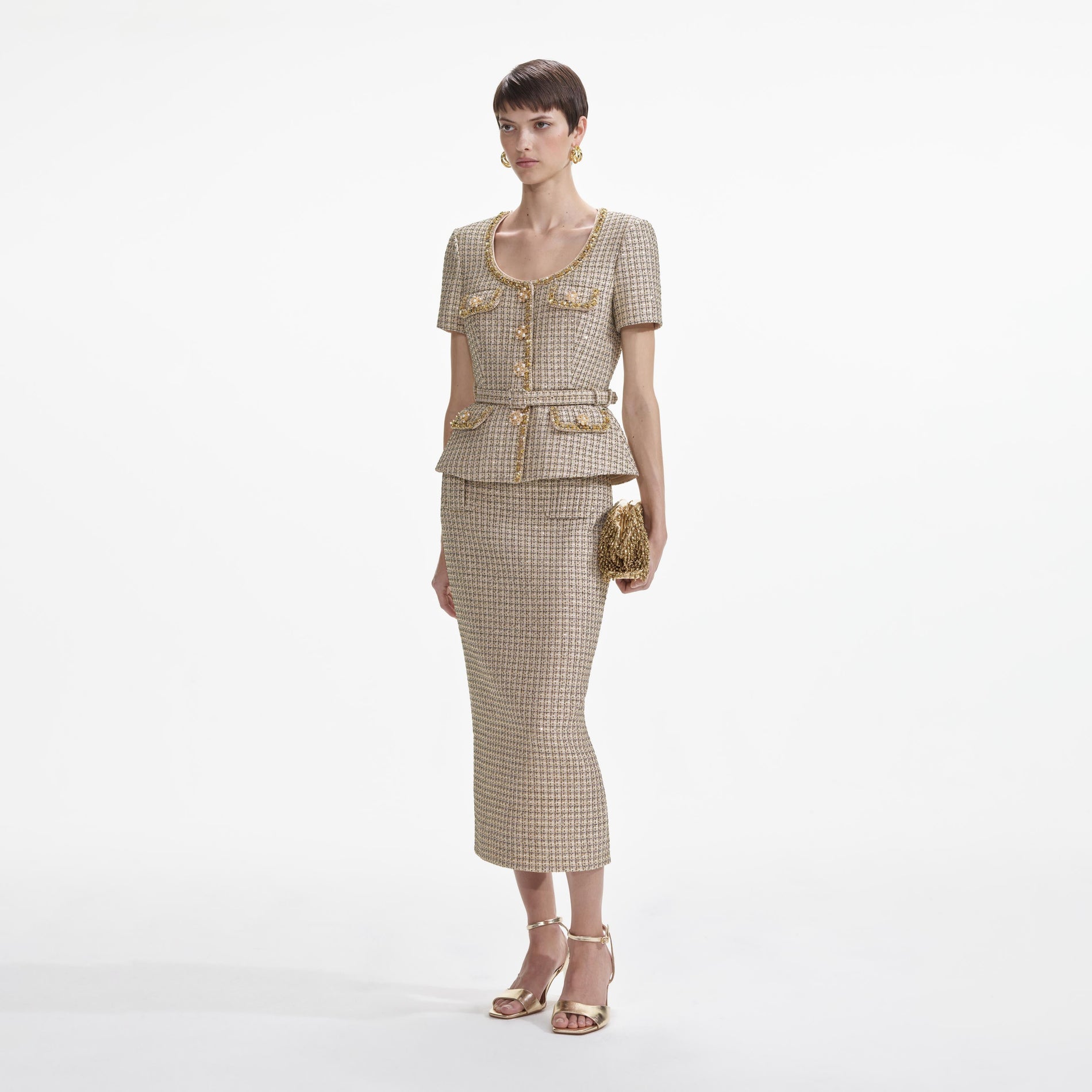 Side view of a woman wearing the Gold Boucle Peplum Top
