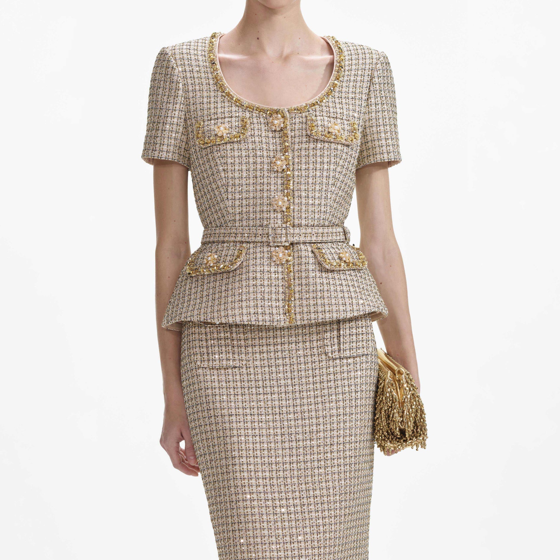 A close up of a woman wearing the Gold Boucle Peplum Top