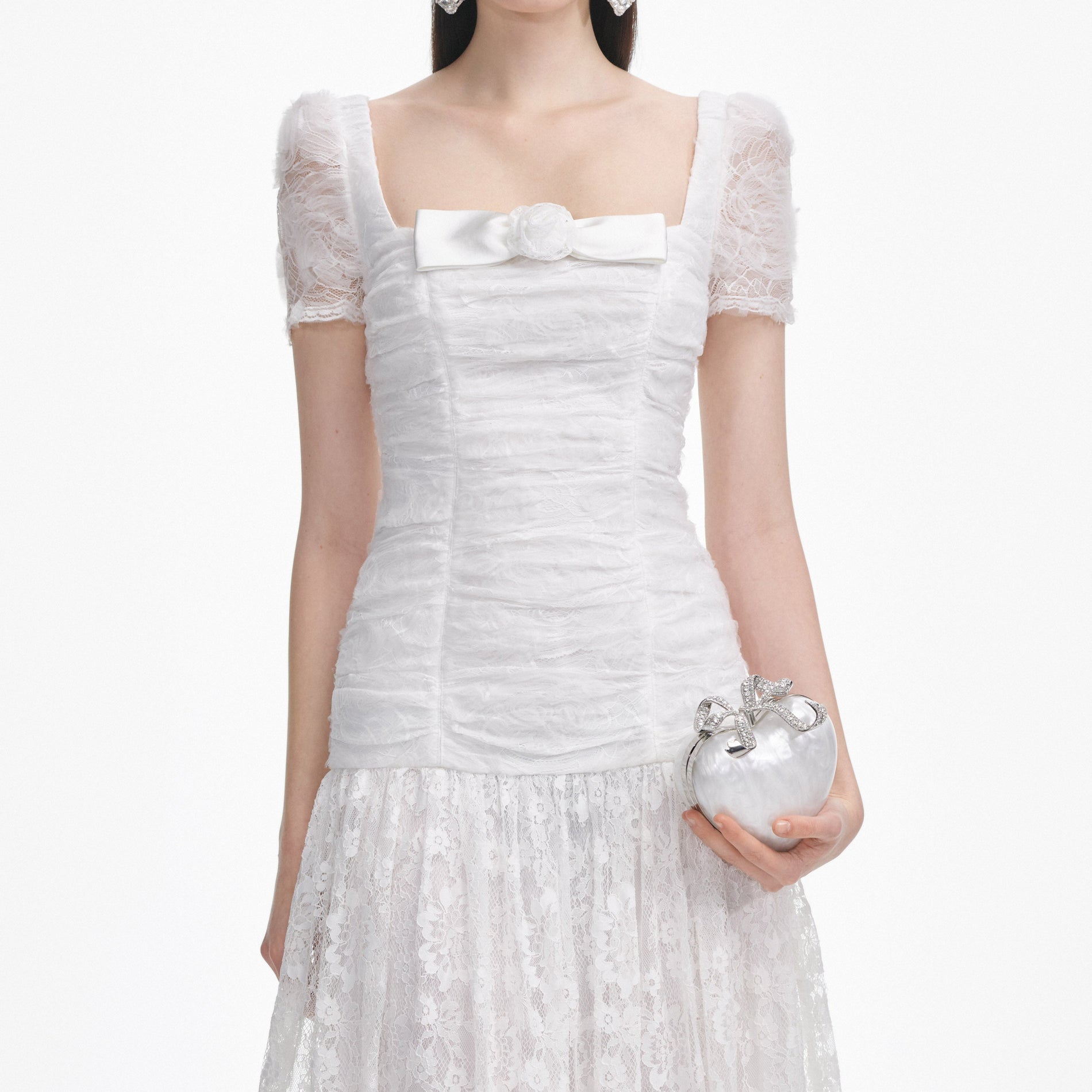 A close up of a woman wearing the White Tulle Lace Gathered Midi Dress