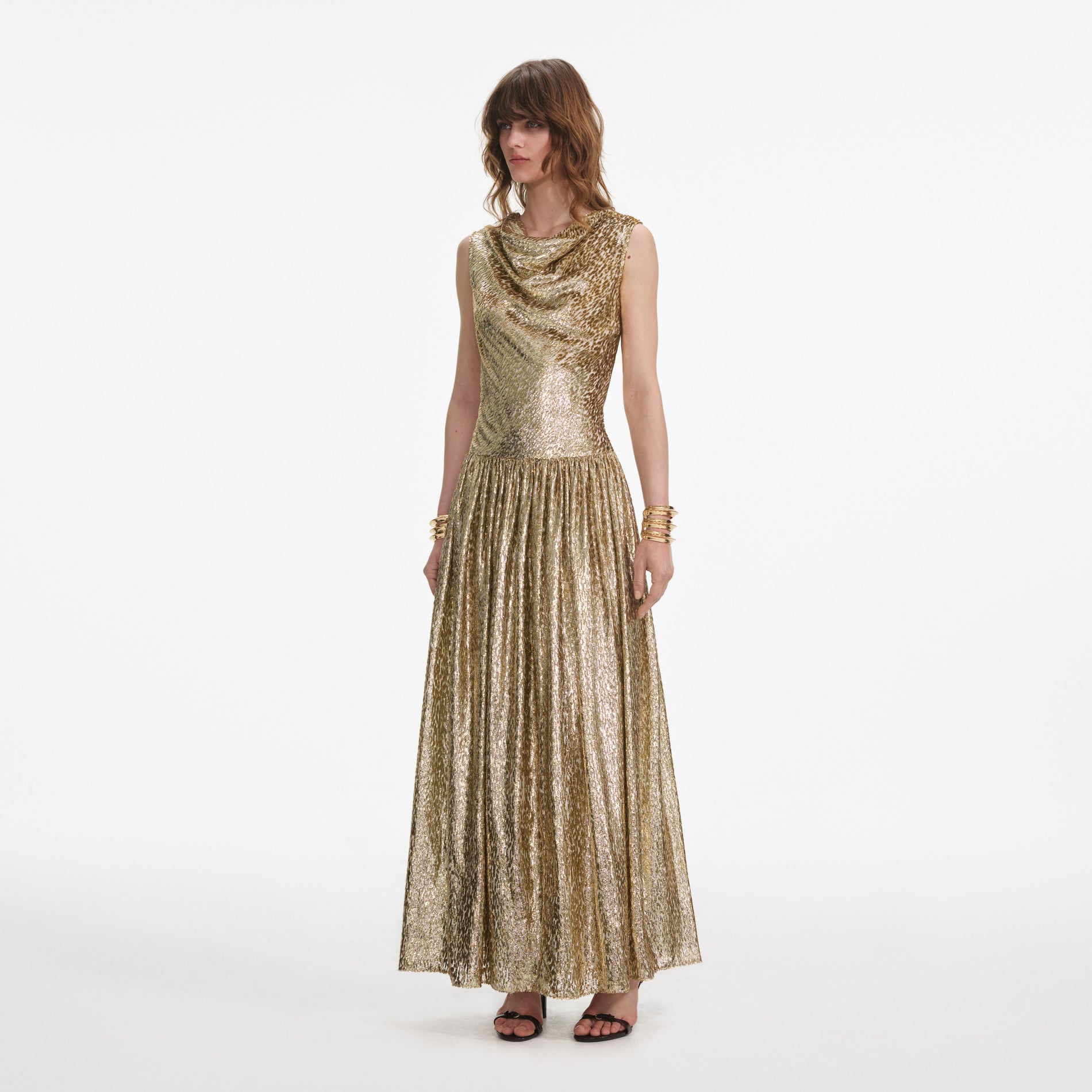Side view of a woman wearing the Gold Sleeveless Fil Coupe Maxi Dress
