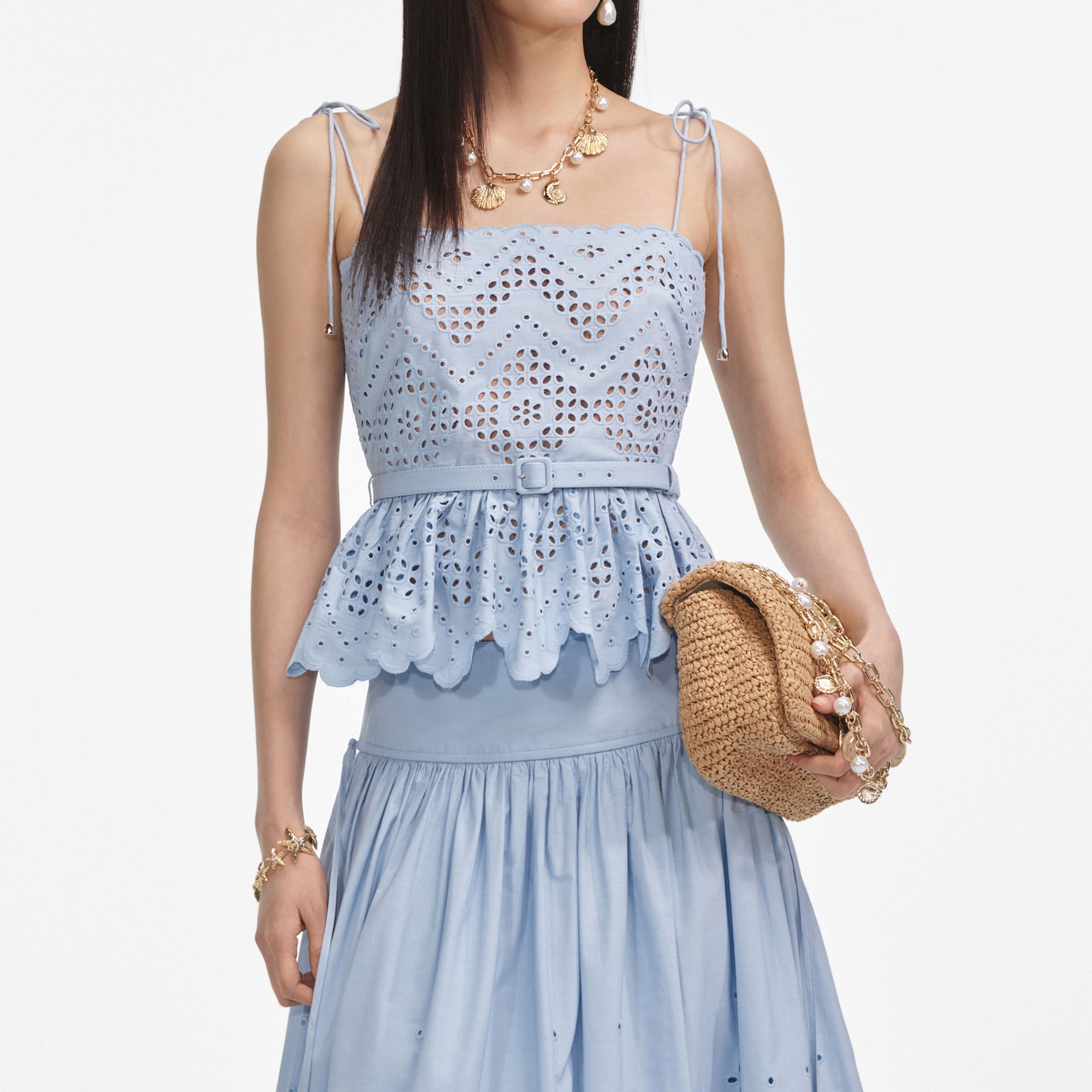 A close up of a woman wearing the Blue Cotton Broderie Top