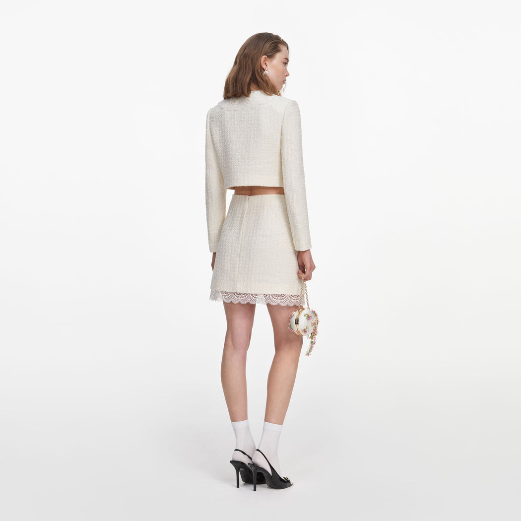 Back view of a woman wearing the Cream Boucle Lace Mini Skirt