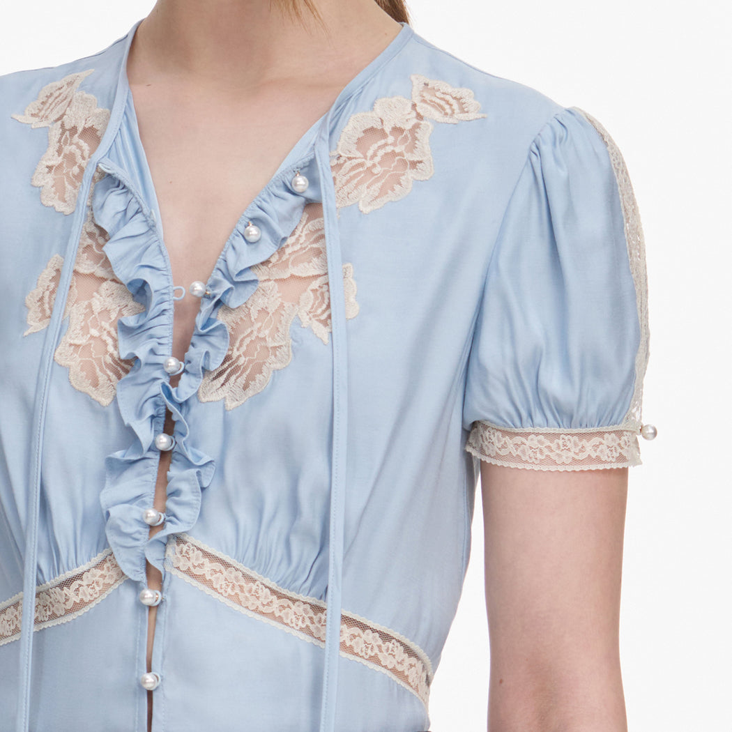 A close up of a woman wearing the Blue Viscose Lace Top