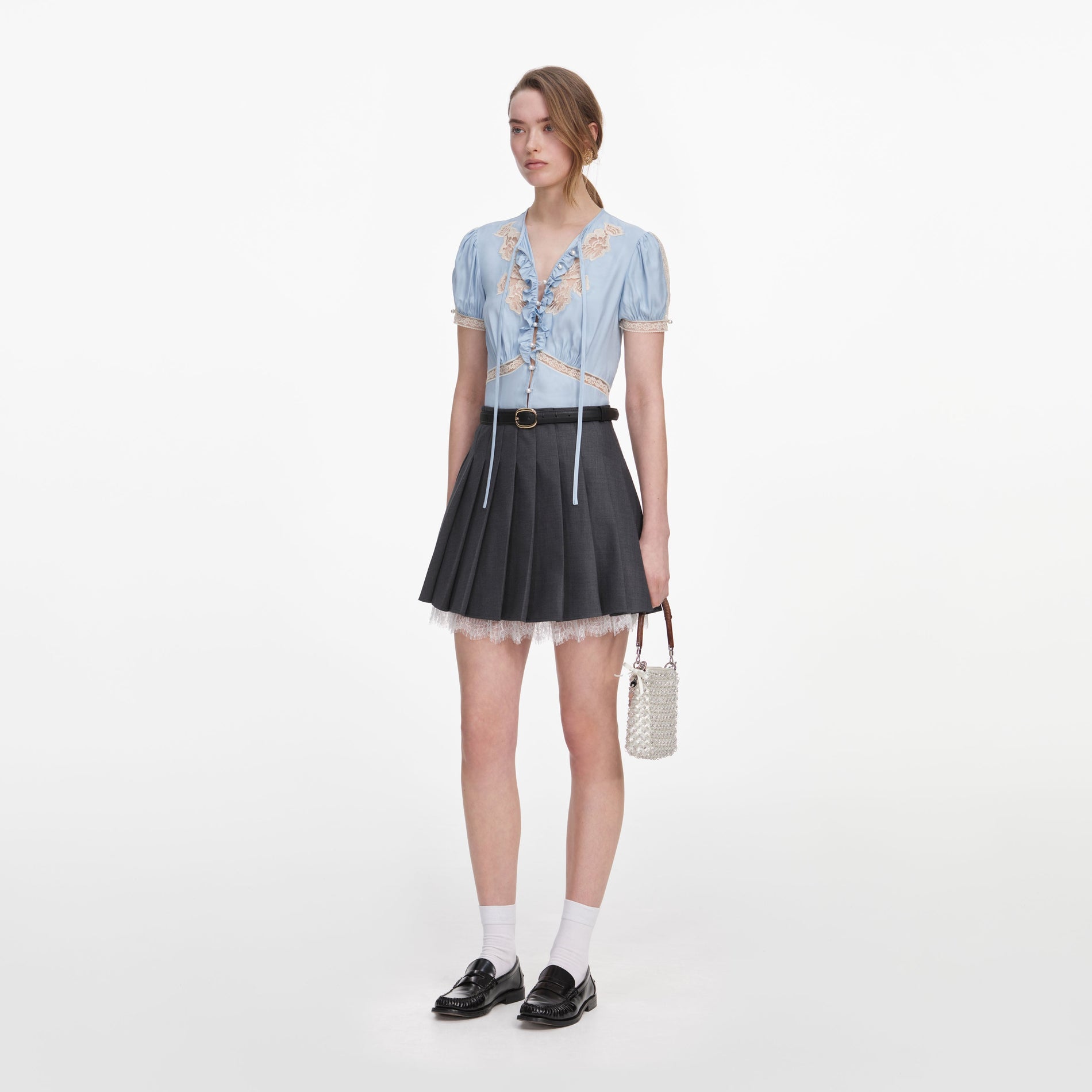 Side view of a woman wearing the Grey Pleated Mini Skirt