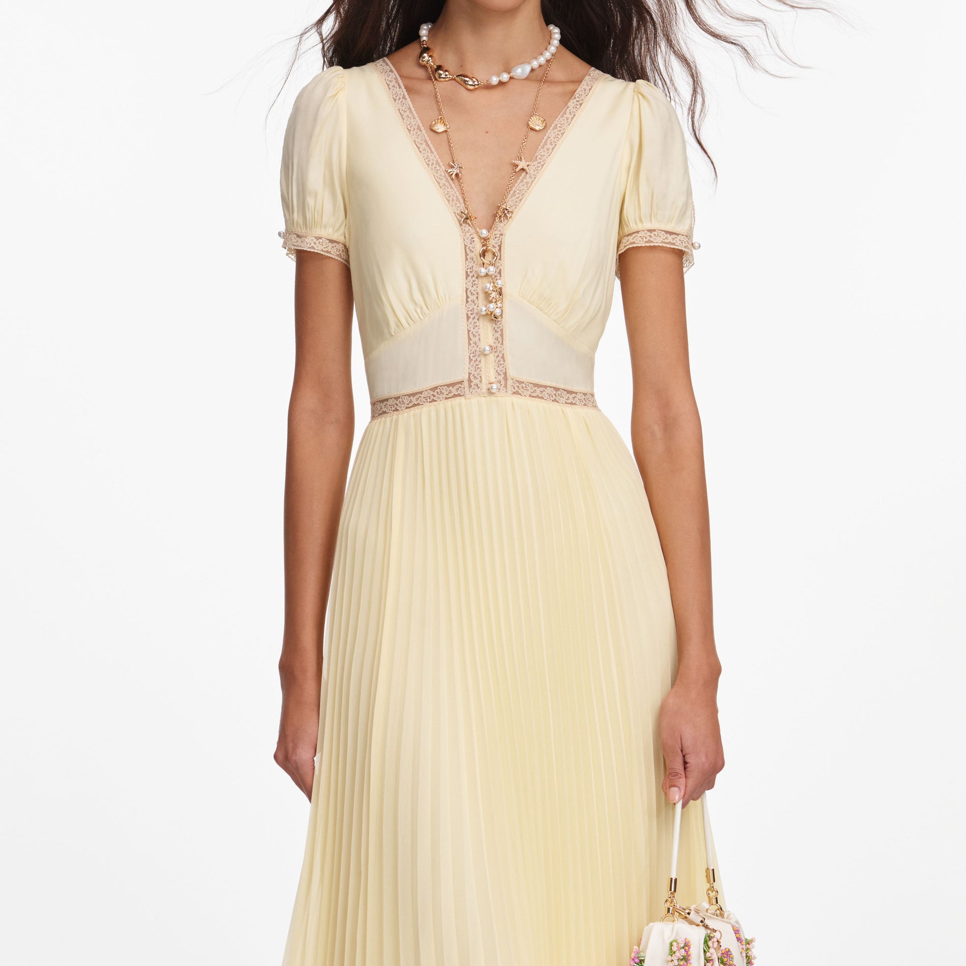 A close up of a woman wearing the Yellow Viscose Pleated Lace Midi Dress