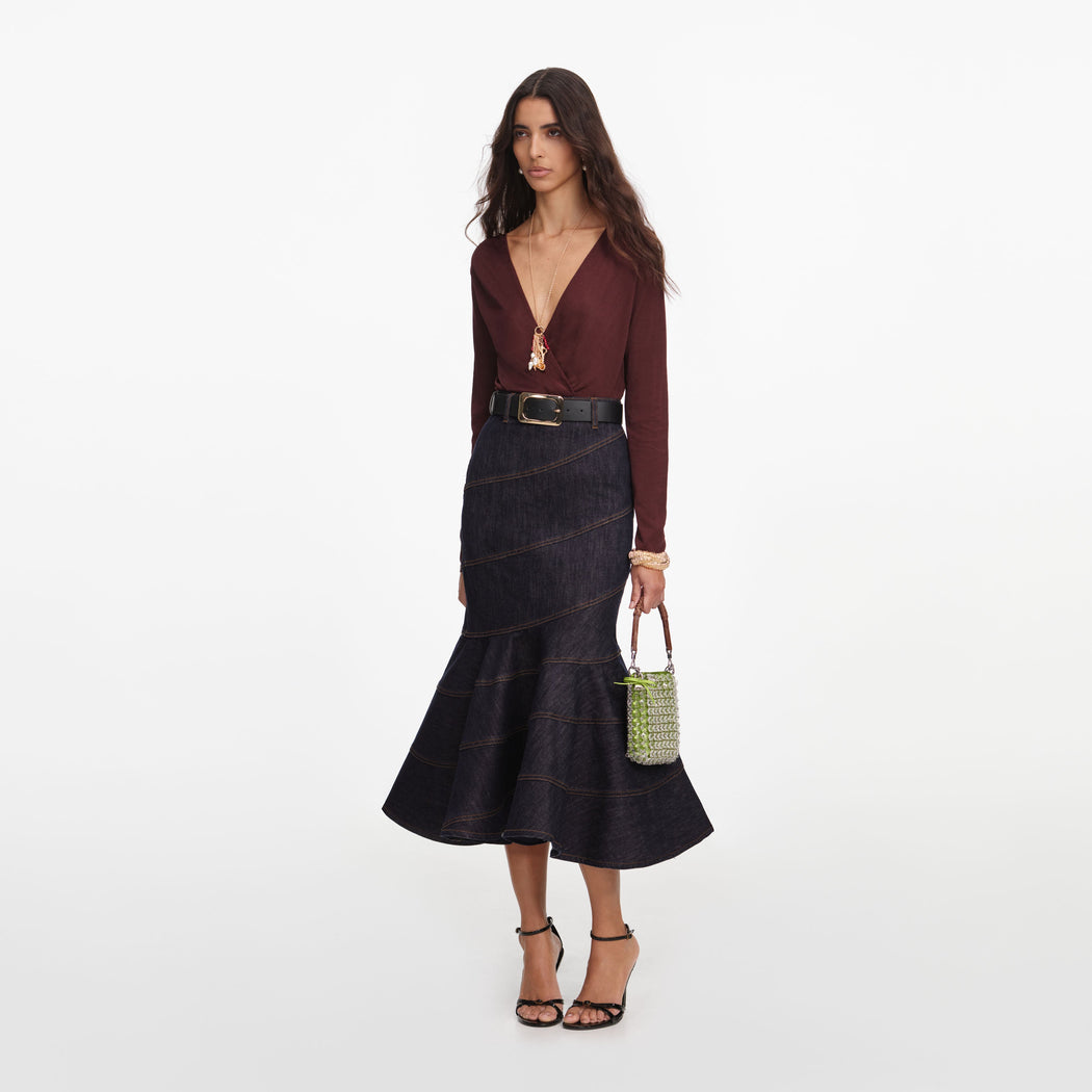 Side view of a woman wearing the Indigo Denim Belted Midi Skirt