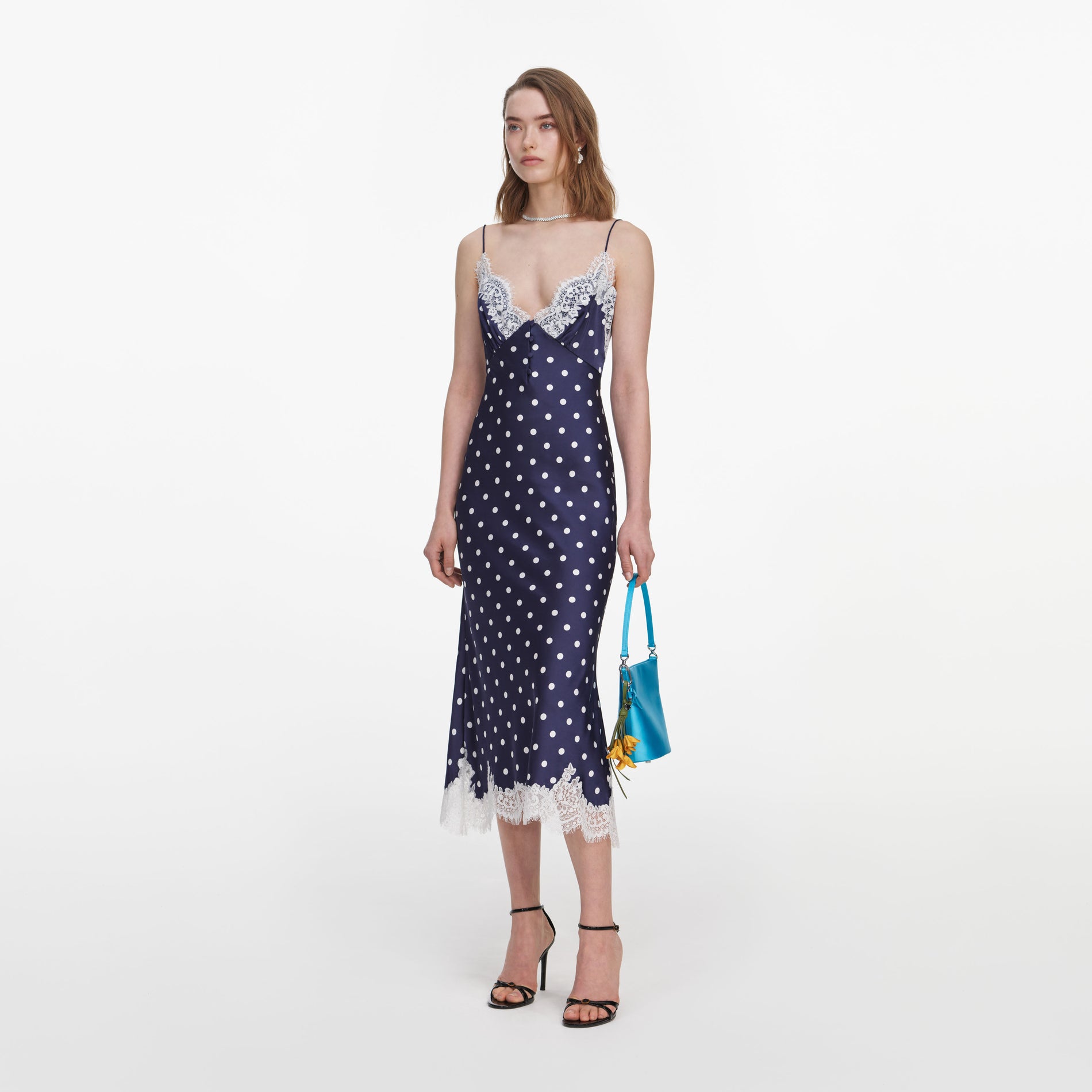 Side view of a woman wearing the Navy Polka Dot Satin Midi Dress