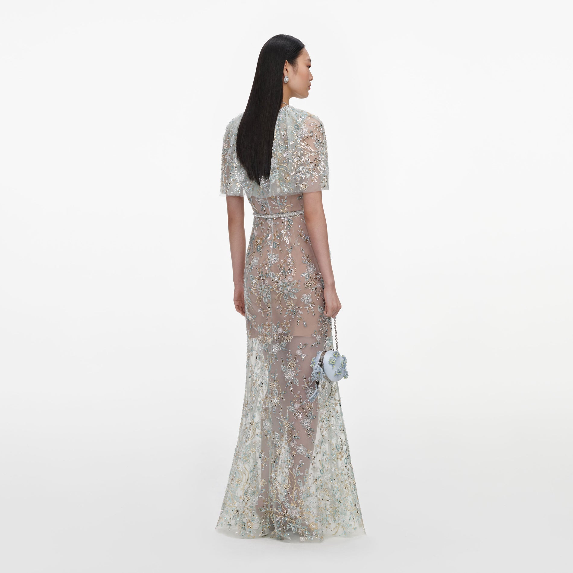 Back view of a woman wearing the Mint Embellished Cape Maxi Dress
