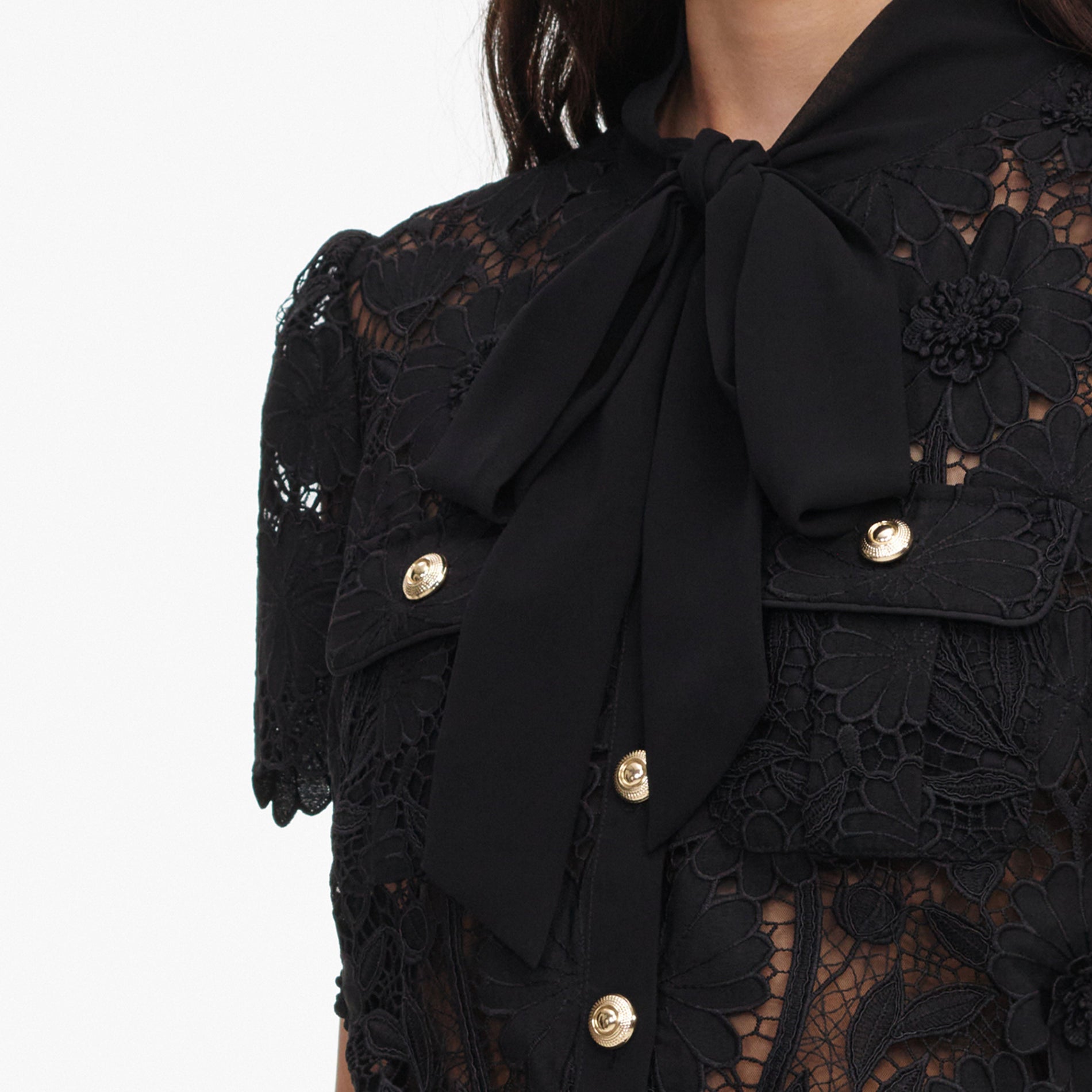 A close up of a woman wearing the Black Lace Tie Neck Top