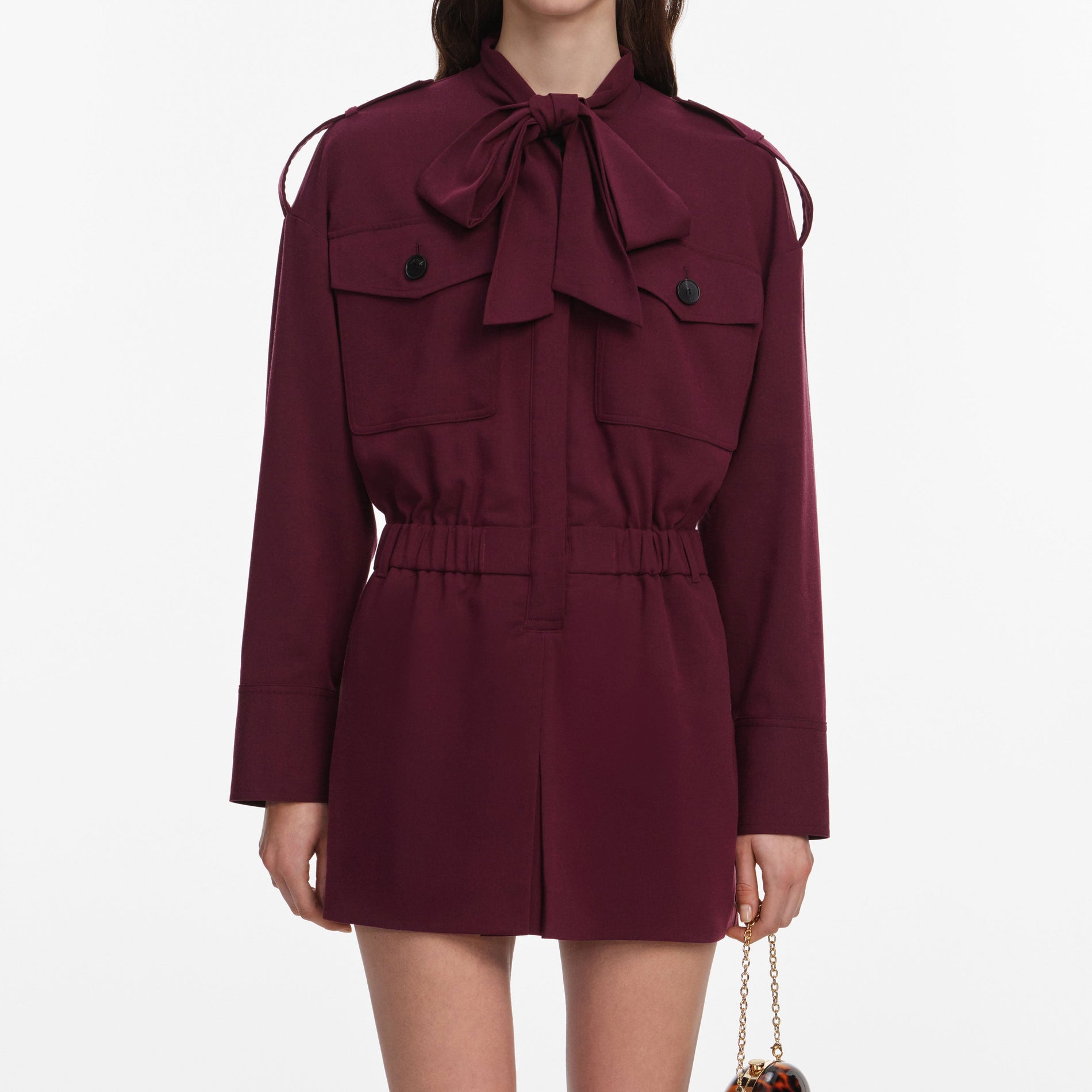 A close up of a woman wearing the Plum Twill Tie Neck Playsuit