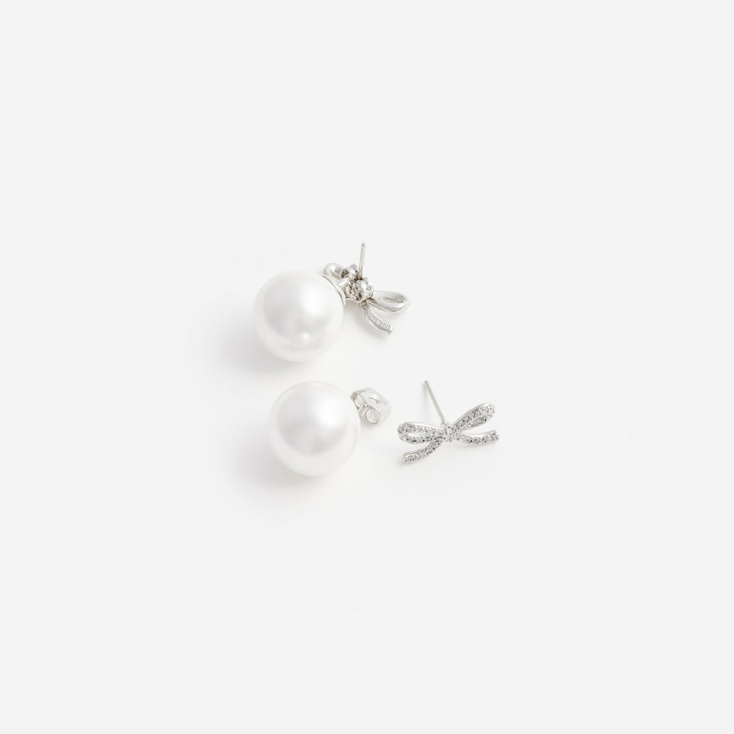 A close up of a woman wearing the Crystal Bow Pearl Back Earrings