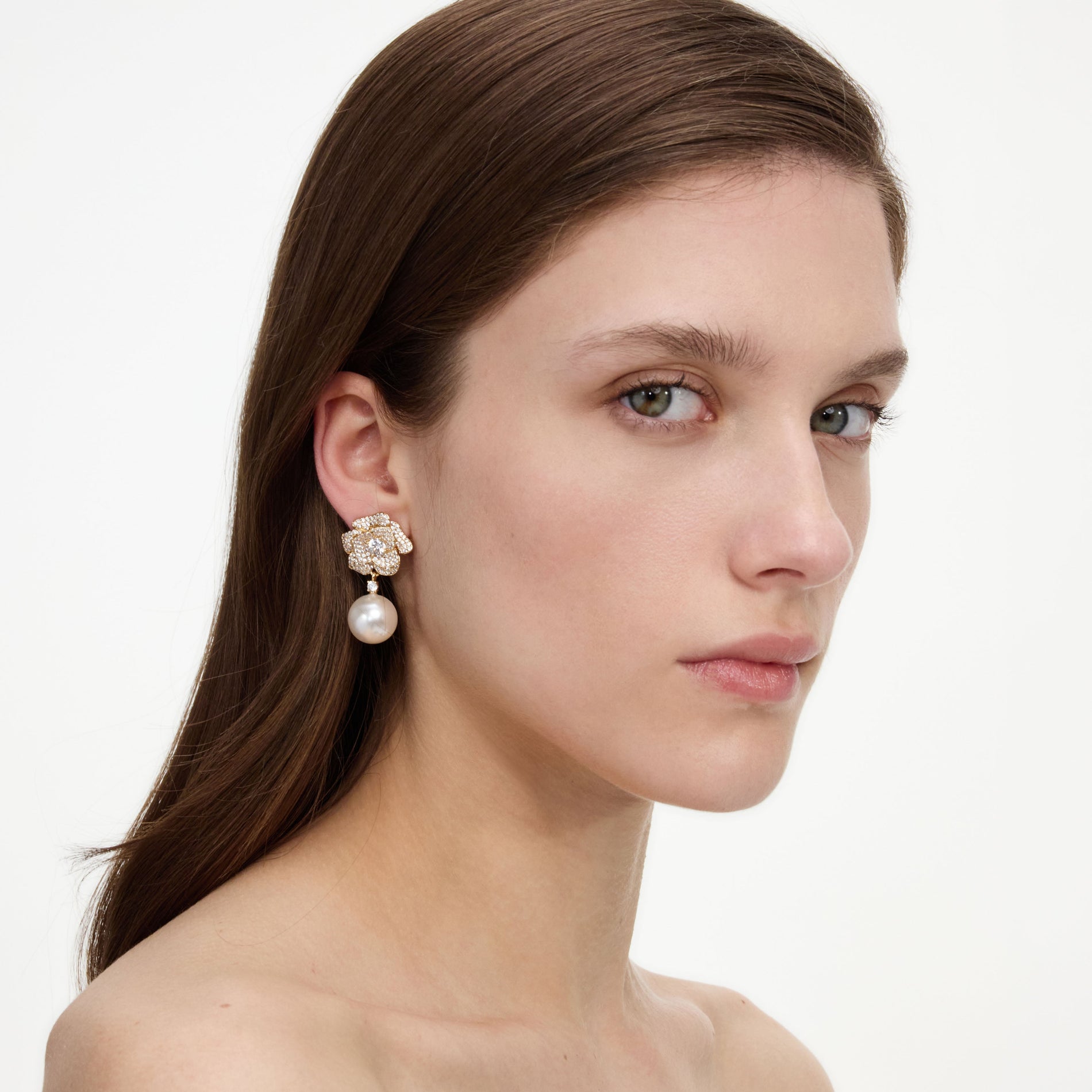 A close up of a woman wearing the Mini Gold Crystal Flower Pearl Earrings