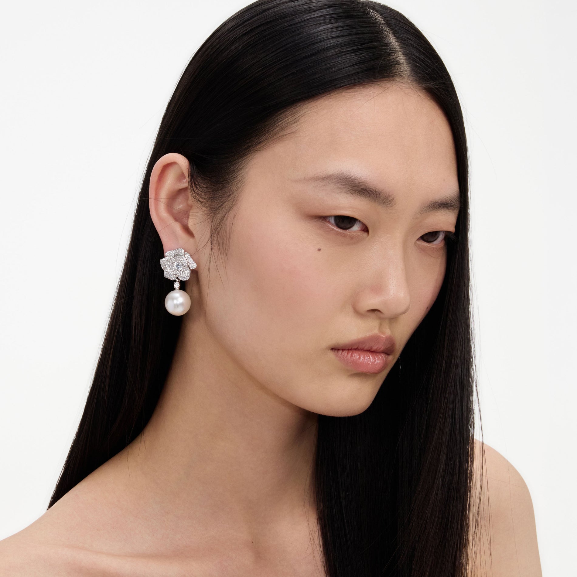 A close up of a woman wearing the Mini Crystal Flower Pearl Earrings