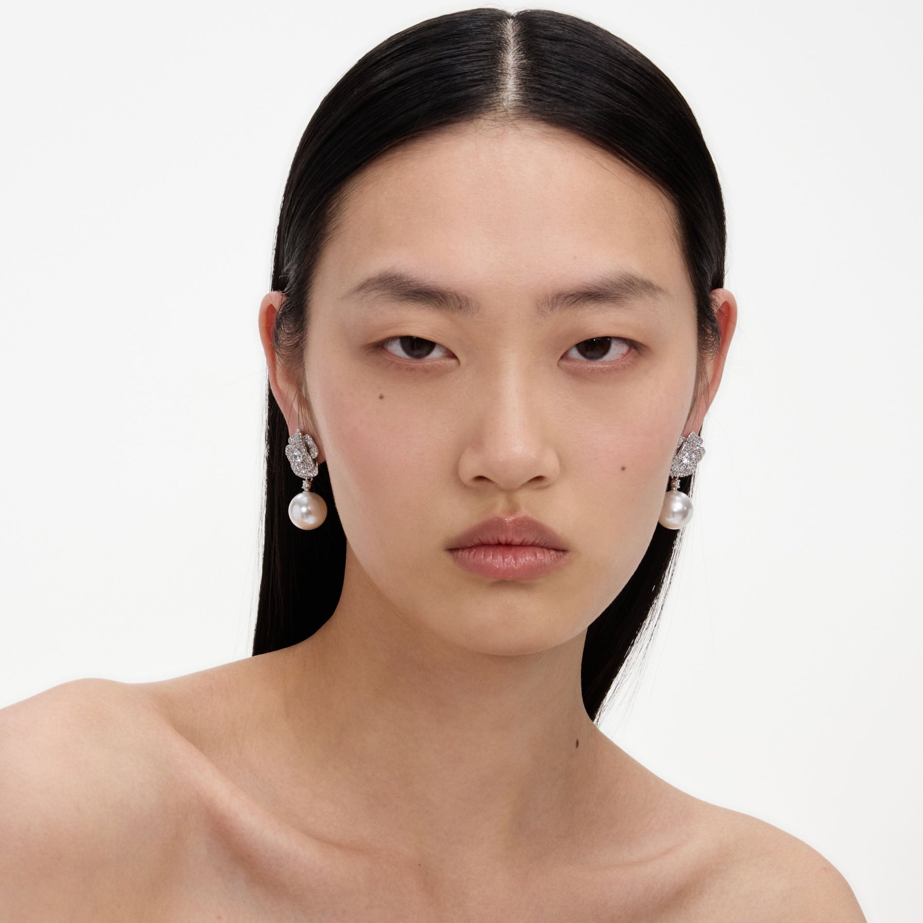 A close up of a woman wearing the Mini Crystal Flower Pearl Earrings