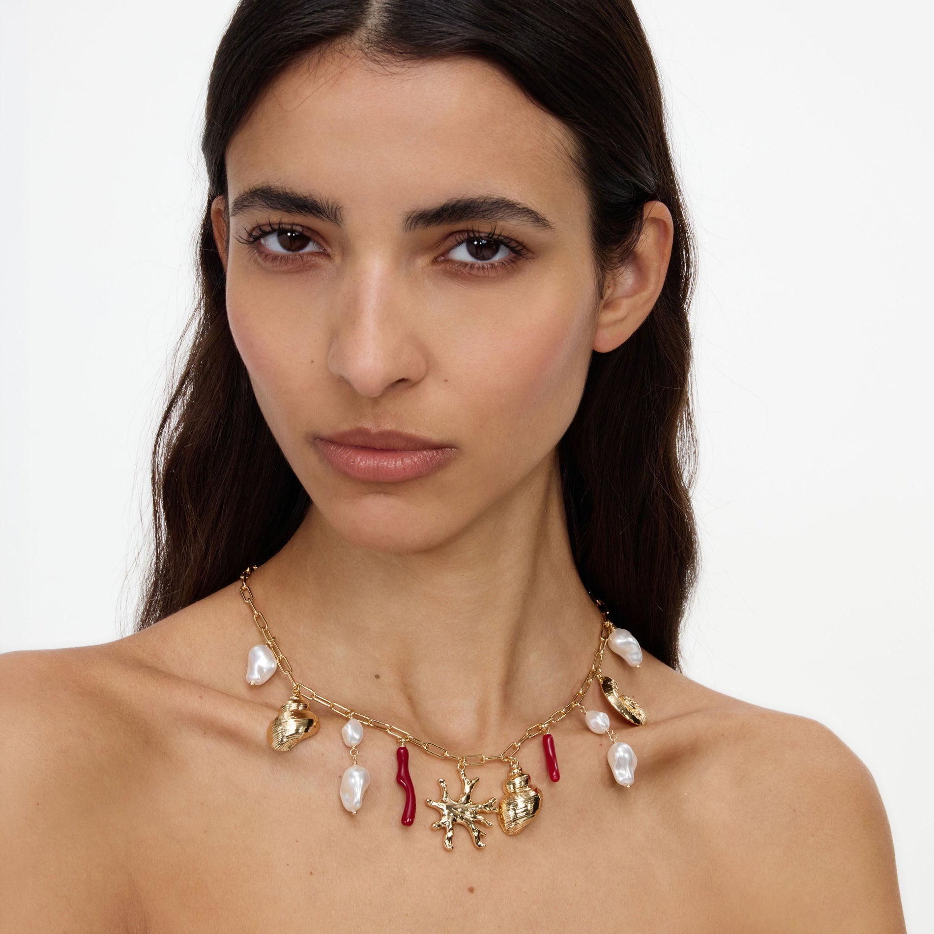 A close up of a woman wearing the Gold Coral Pearl Charm Necklace