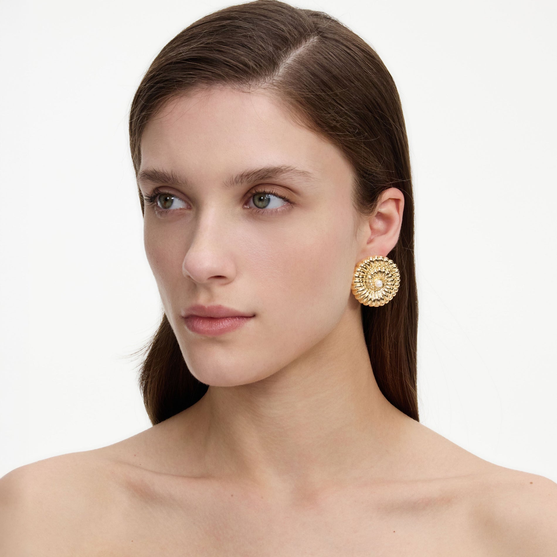 A close up of a woman wearing the Gold Pearl Shell Earrings