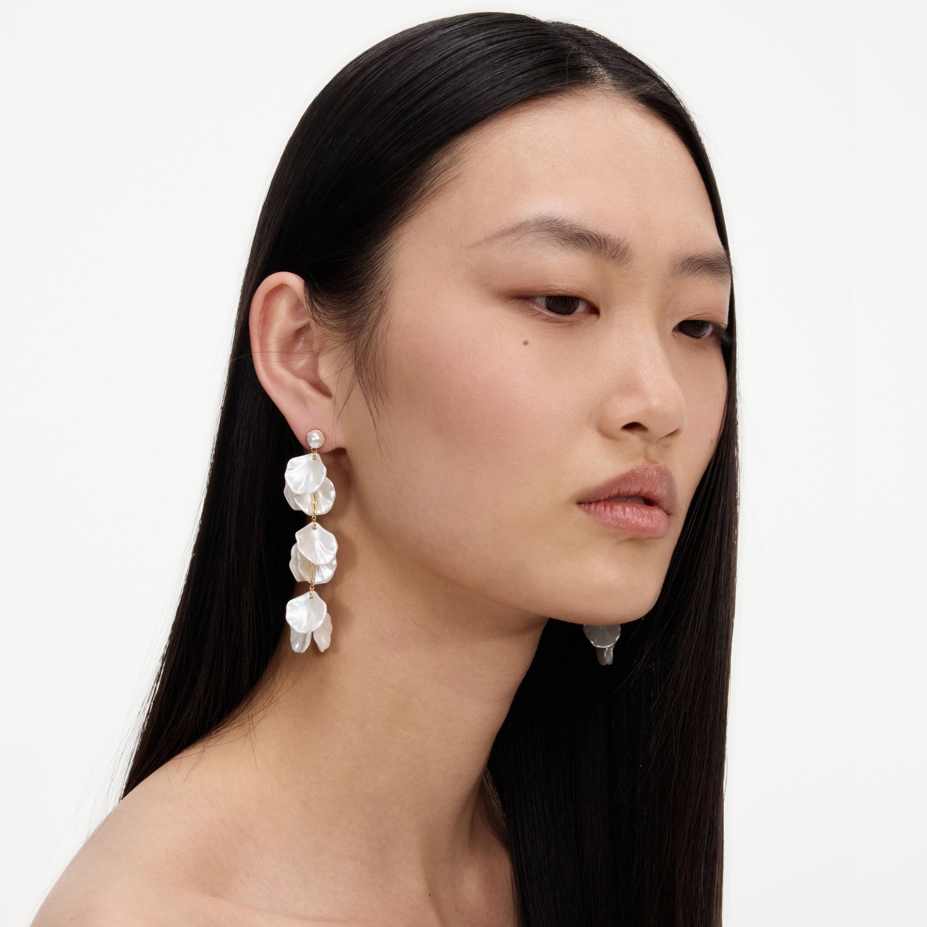 A close up of a woman wearing the Pearl Petal Tiered Earrings