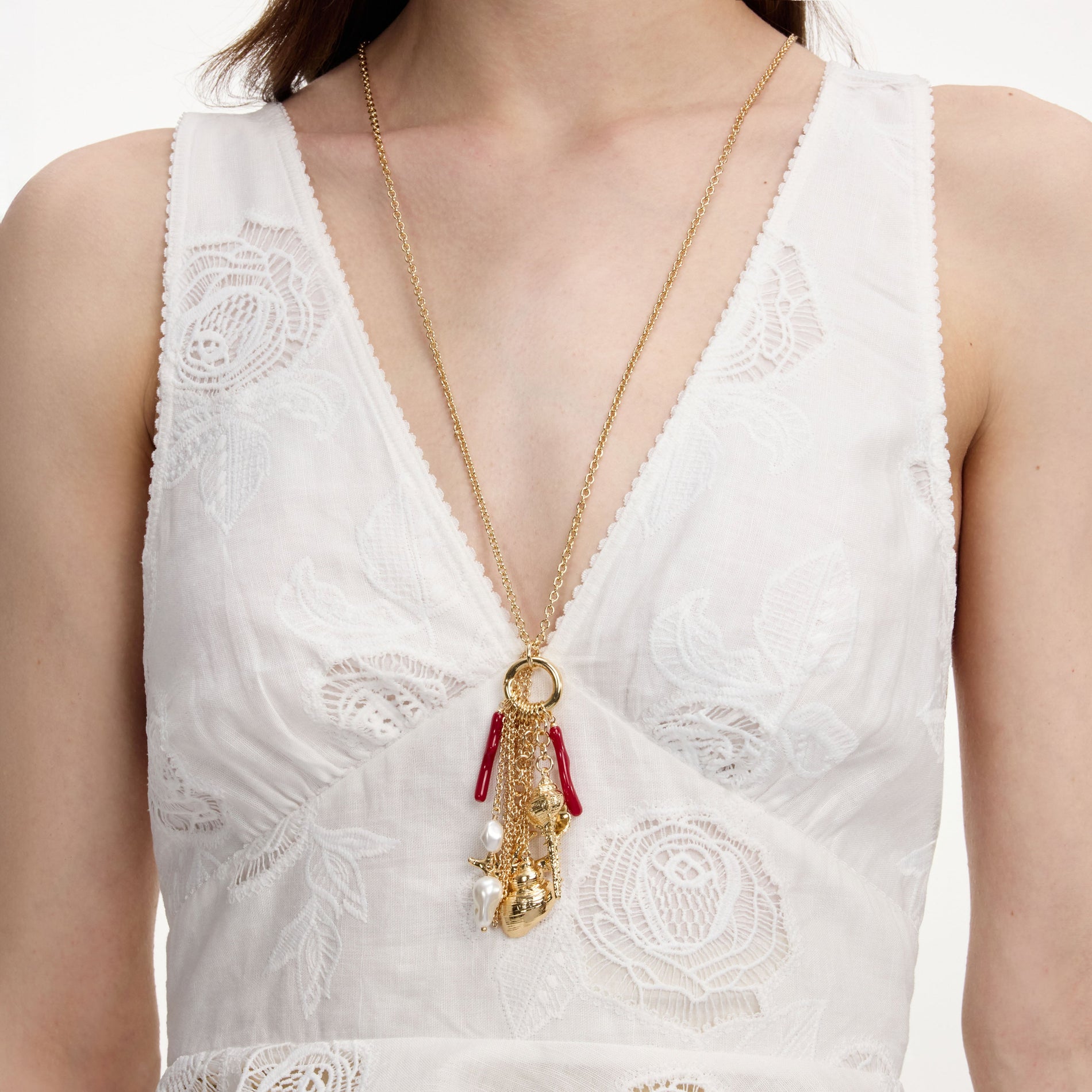 A close up of a woman wearing the Gold Coral Charm Cluster Necklace