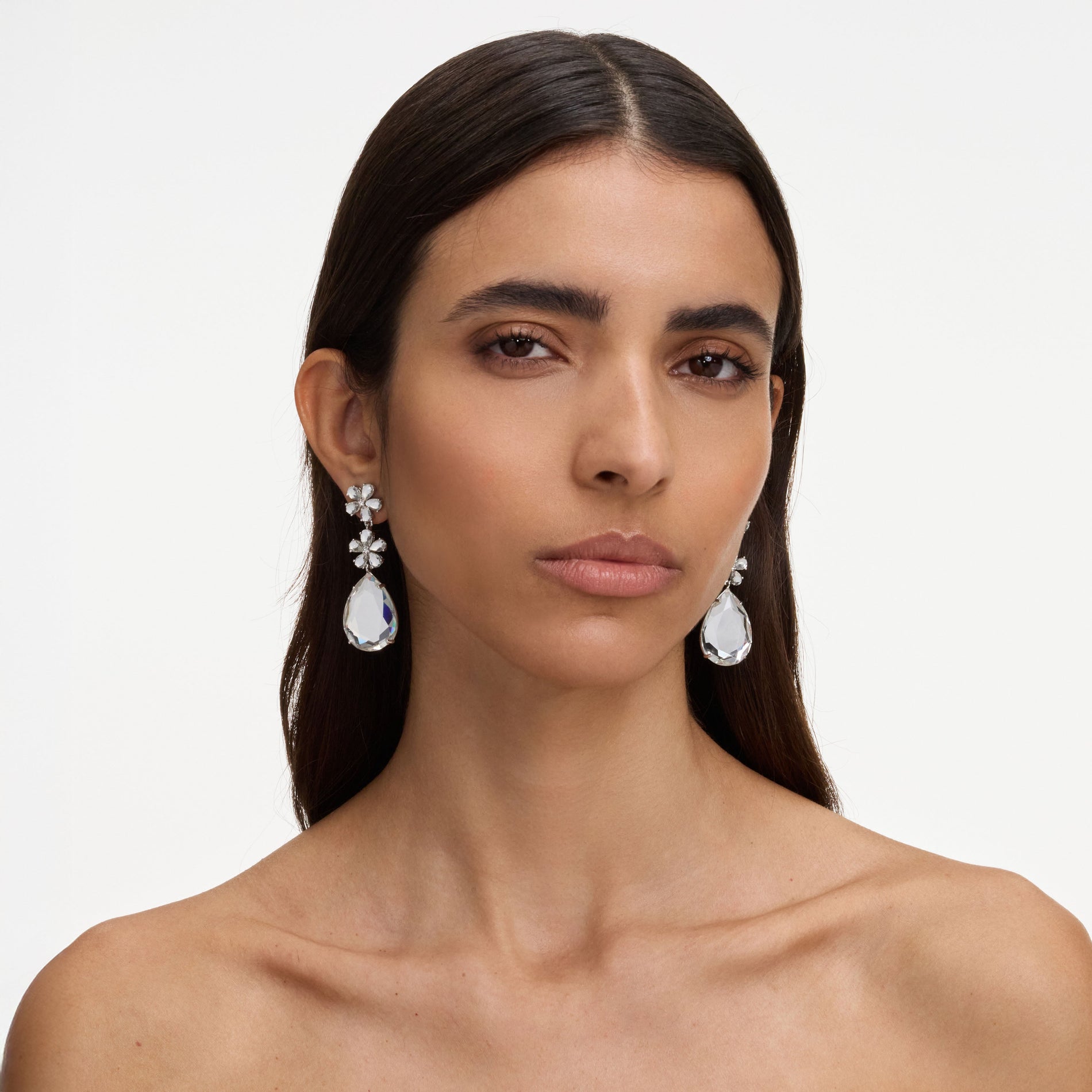 A close up of a woman wearing the Crystal Flower Tiered Earrings