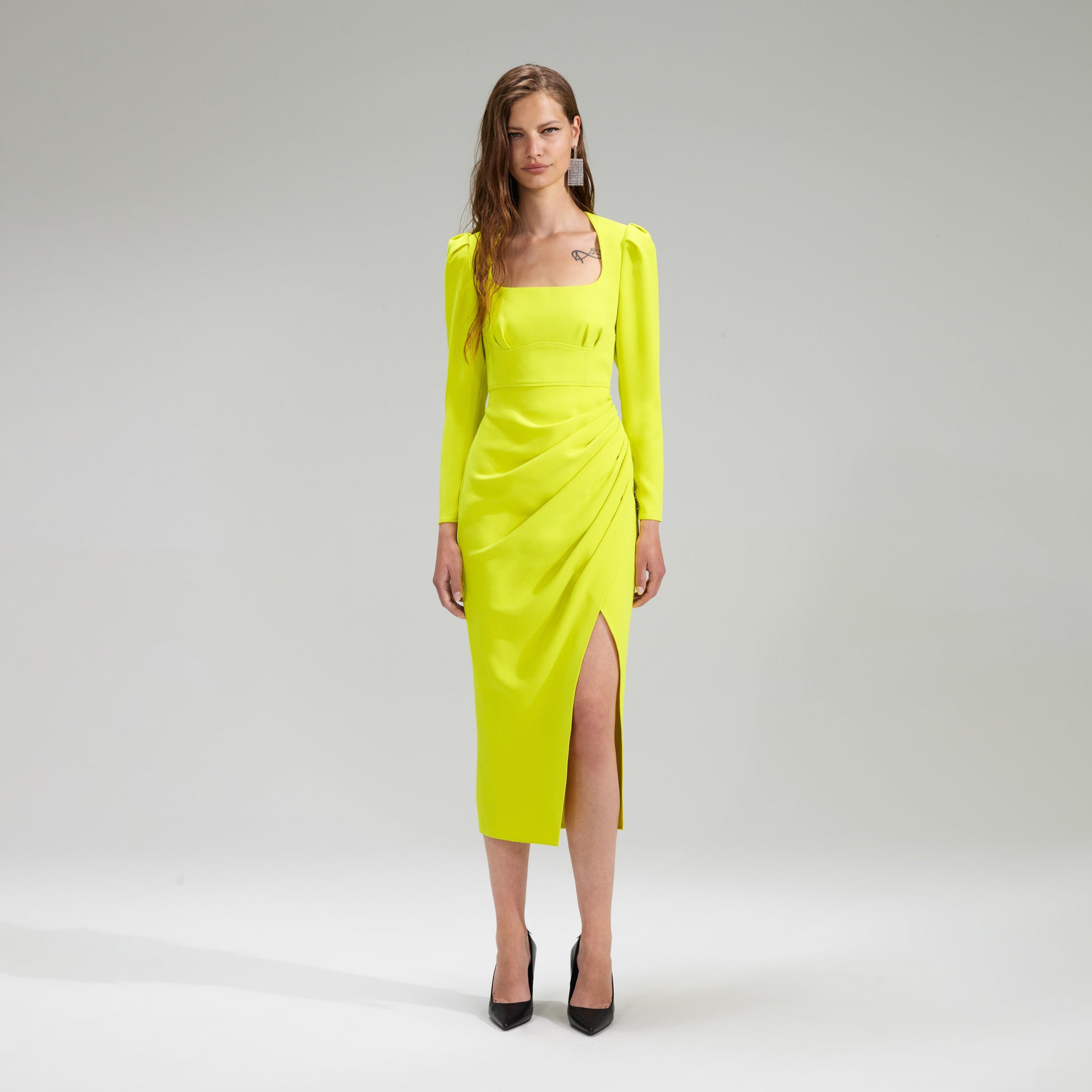 A woman wearing the Lime Crepe Ruched Midi Dress