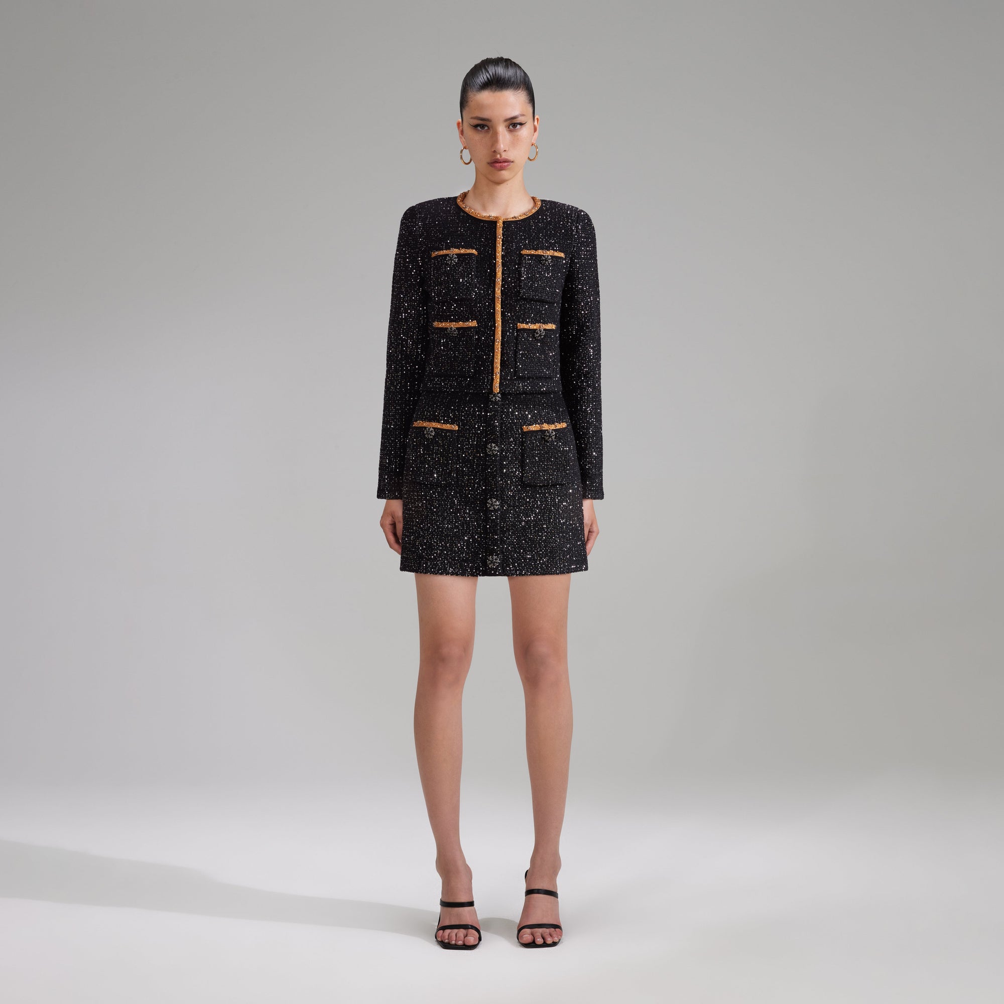 A woman wearing the Black Sequin Knit Mini Skirt