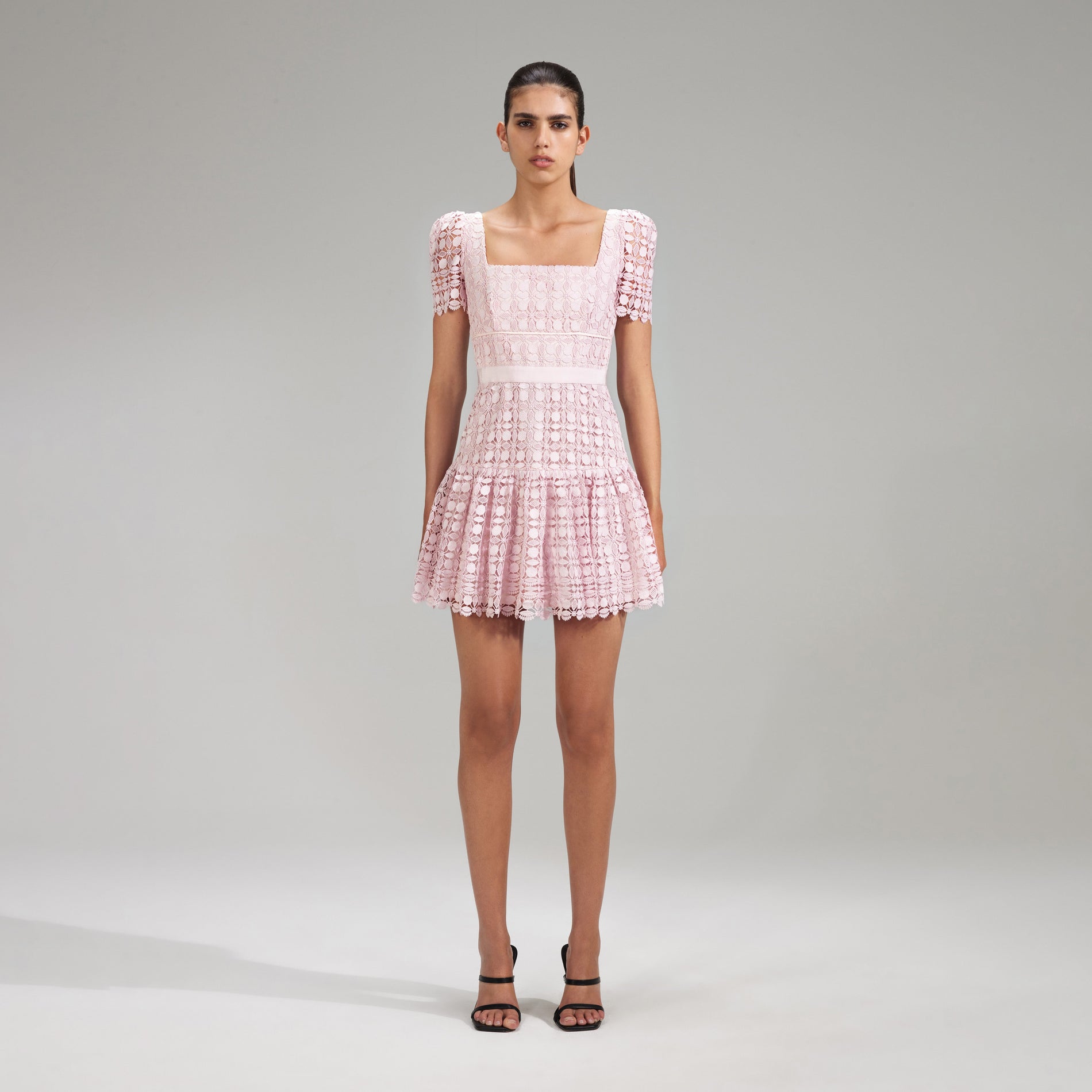 A woman wearing the Pink Petal Lace Mini Dress