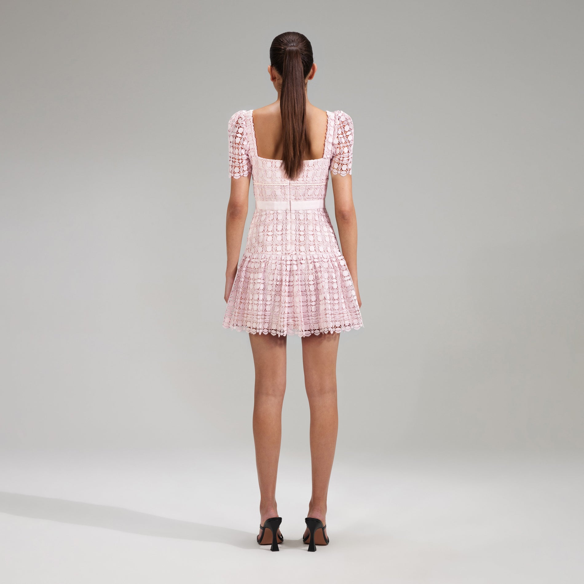 A woman wearing the Pink Petal Lace Mini Dress