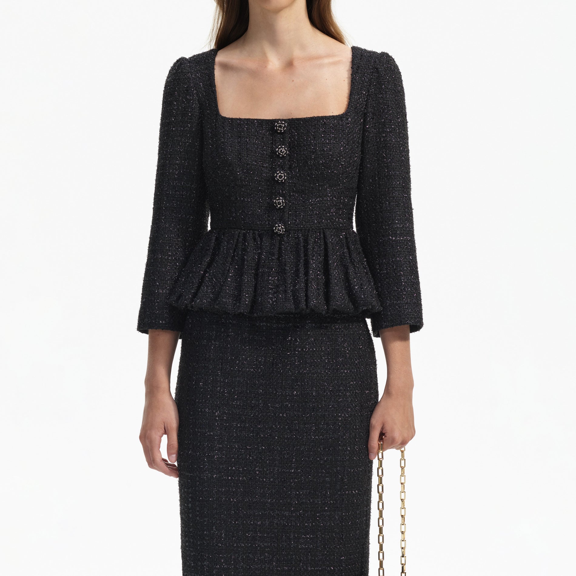 A close up of a woman wearing the Black Boucle Peplum Midi Dress