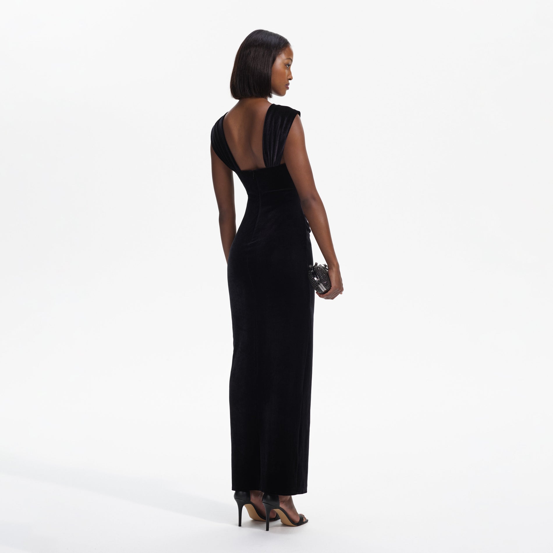 Back view of a woman wearing the Black Velvet Cut-Out Slit Maxi Dress