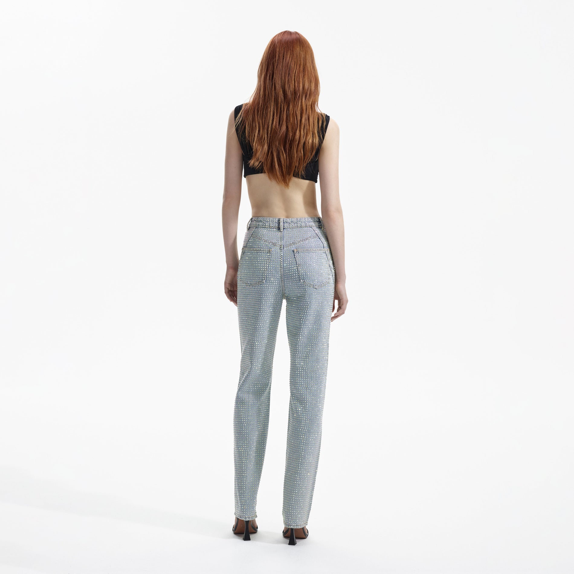 Back view of a woman wearing the Blue Rhinestone Denim Jeans