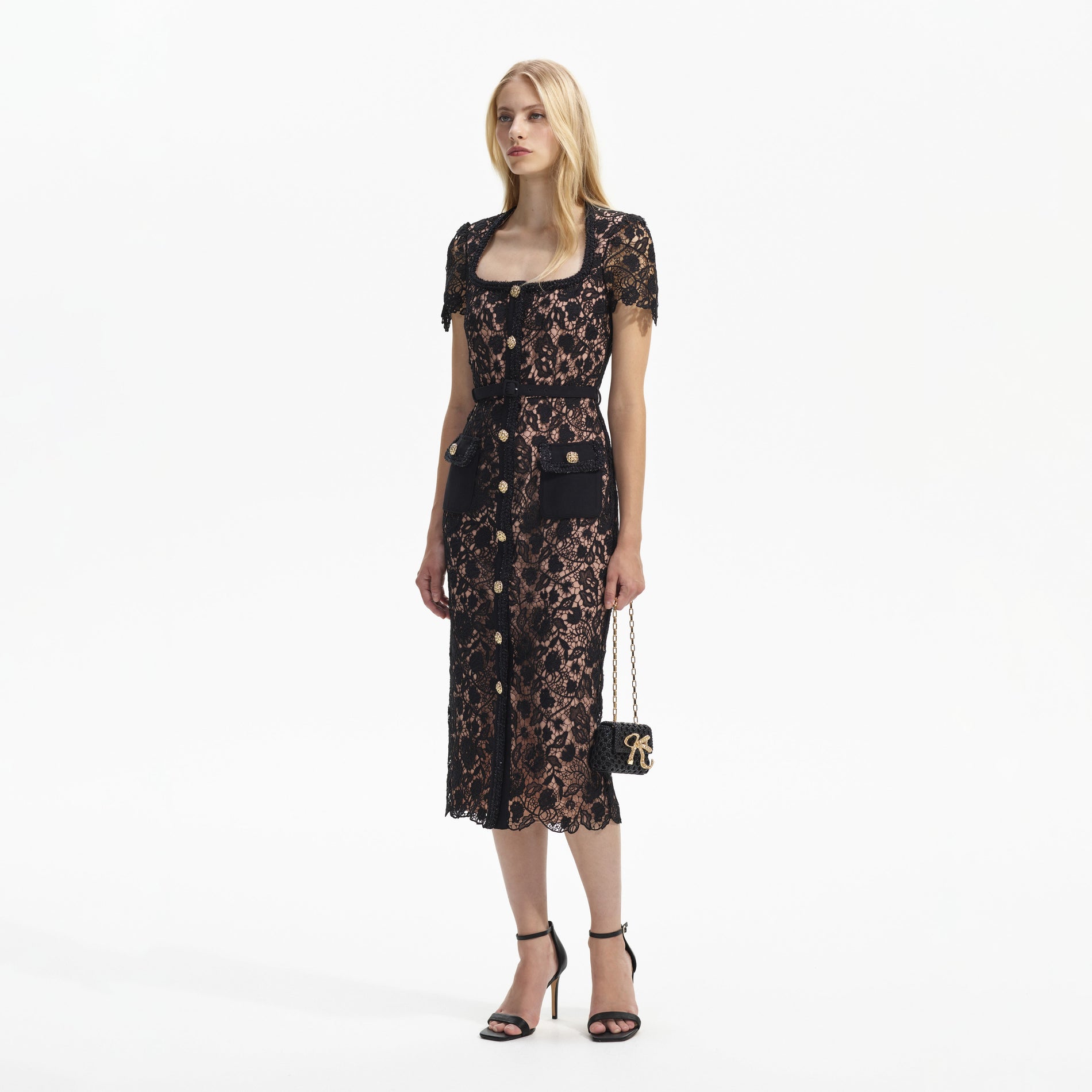 Side view of a woman wearing the Black Guipure Lace Short Sleeve Midi Dress